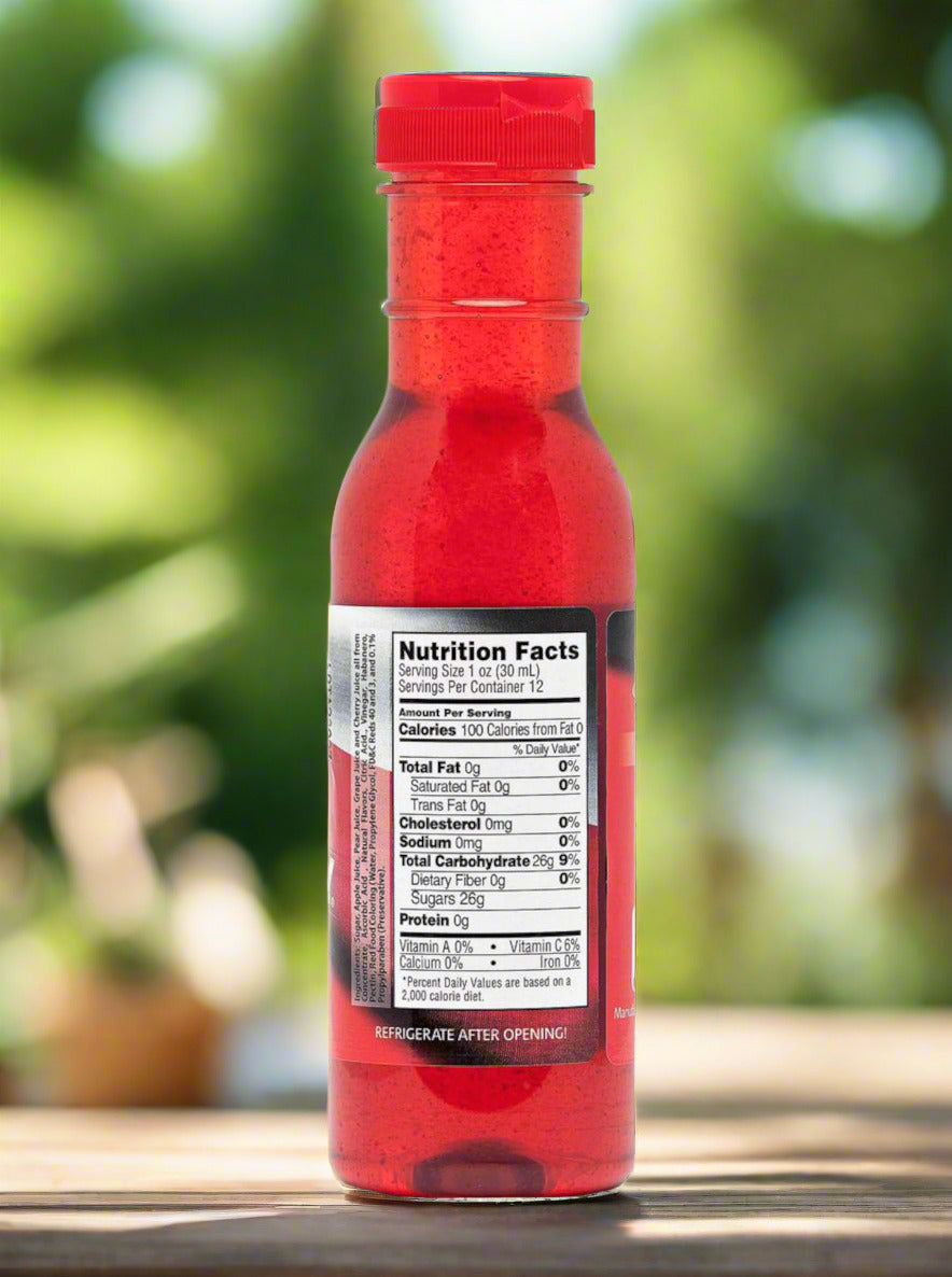 A picture of a the back of a plastic bottle of Texas Pepper Jelly's "The Original Rib Candy", Apple Cherry Habanero flavor. The bottle is cylindrical and clear & the top is covered by a plastic red flip top.Inside the bottle is a bright red thick fluid, with air bubbles suspended in the fluid. The bottom of the label under the nutrition facts reads REFRIGERATE AFTER OPENING. The background shows the bottle on a wooden table in a backyard.