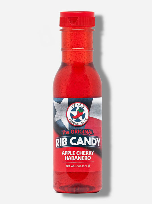 A picture of a plastic bottle of Texas Pepper Jelly's "The Original Rib Candy", Apple Cherry Habanero flavor.  The bottle is cylindrical and clear & the top is covered by a plastic red flip top.  The label reads: THE ORIGINAL RIB CANDY APPLE CHERRY HABANERO, NET WT 17 OZ in red and white text.  Behind the text is the Texas flag in red, white, and blue.  Inside the bottle is a bright red thick fluid, with air bubbles suspended in the fluid.