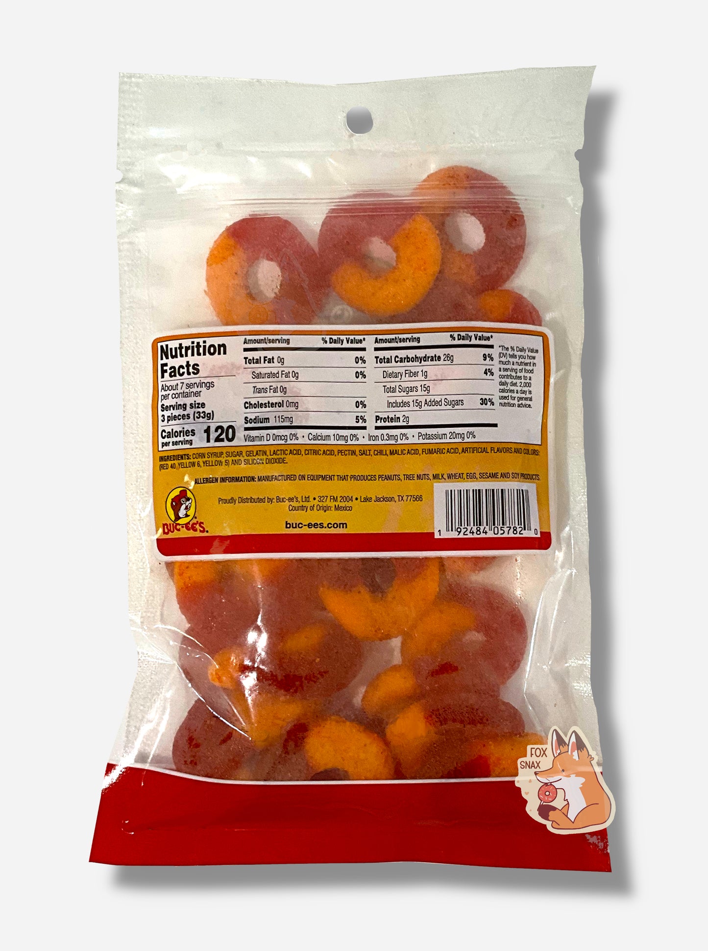 A picture of the back of a clear plastic bag of Buc-ee's Chamoy Peach Rings. Inside the bag, peach rings can be seen; they are half red and half orange.