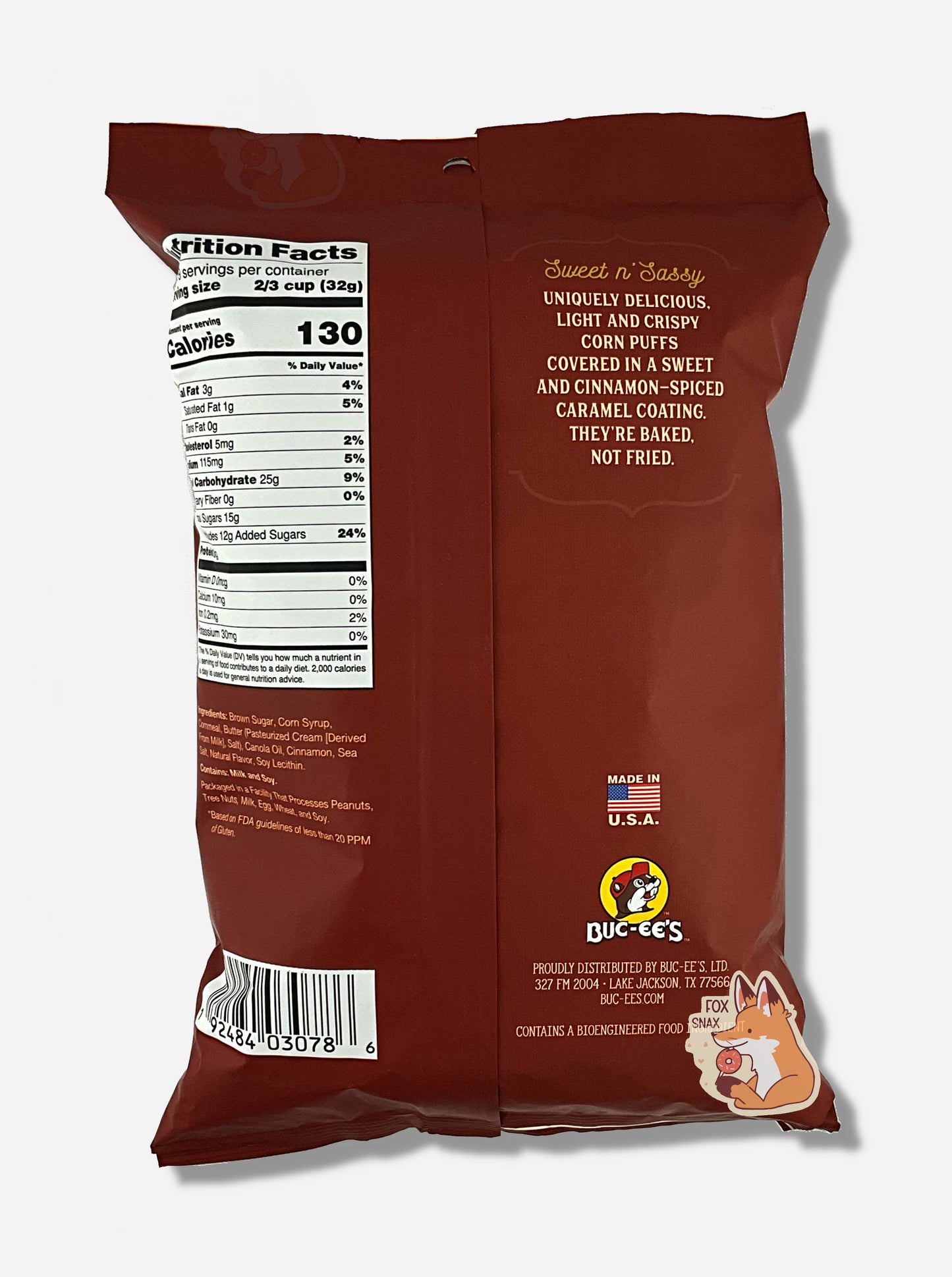 A picture of the back of a opaque, brown and white bag of Buc-ee's Cinnamon Sweet Beaver Nuggets. The bag reads: Sweet n' Sassy, Uniquely delicious, Light And Crispy, Corn Puffs covered in a sweet and cinnamon-spiced caramel coating.. They're baked not fried.
