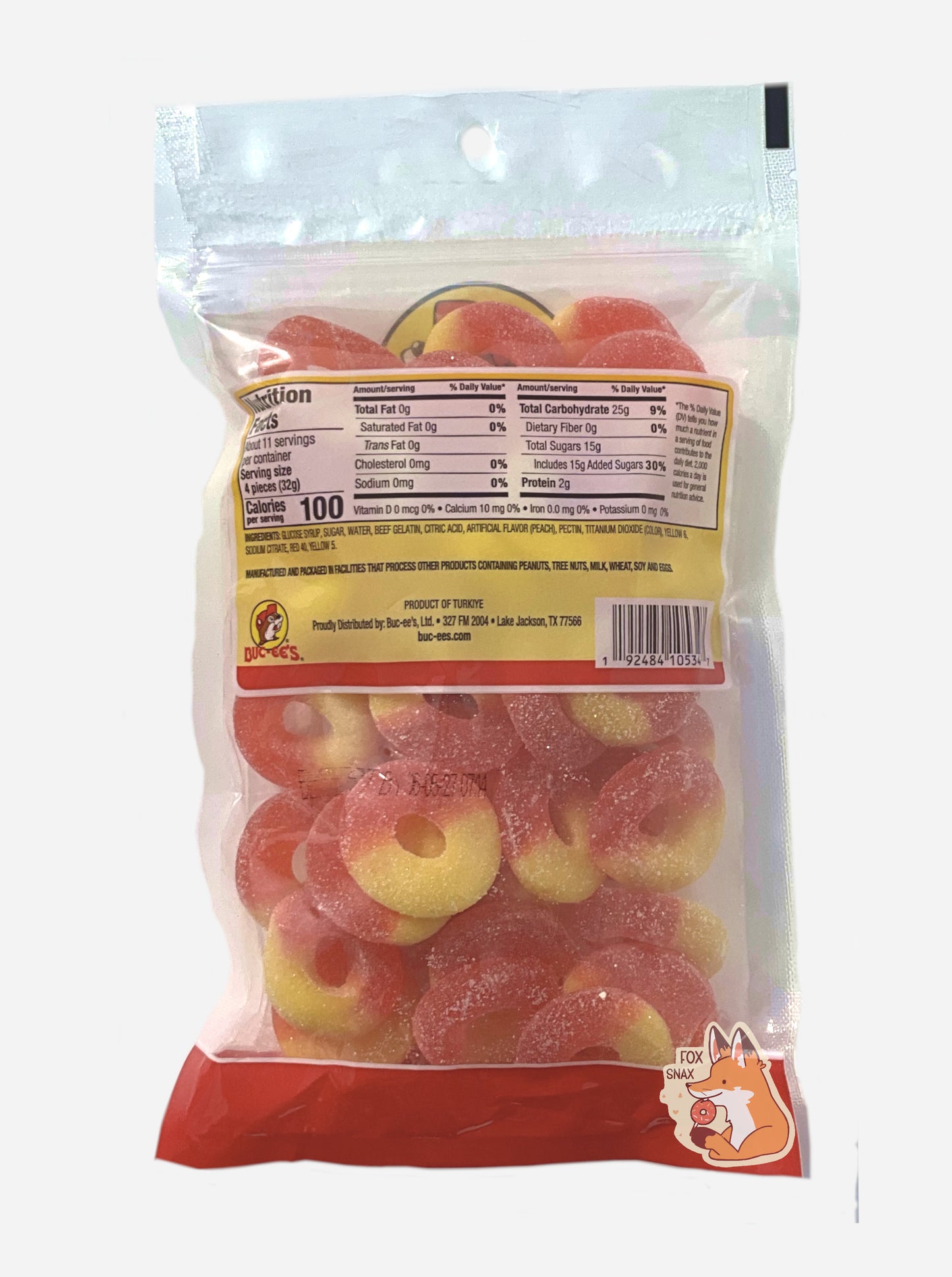 A picture of the back of a clear plastic bag of Buc-ee's Peach Rings. Inside the bag, peach rings can be seen; they are half red and half orange.