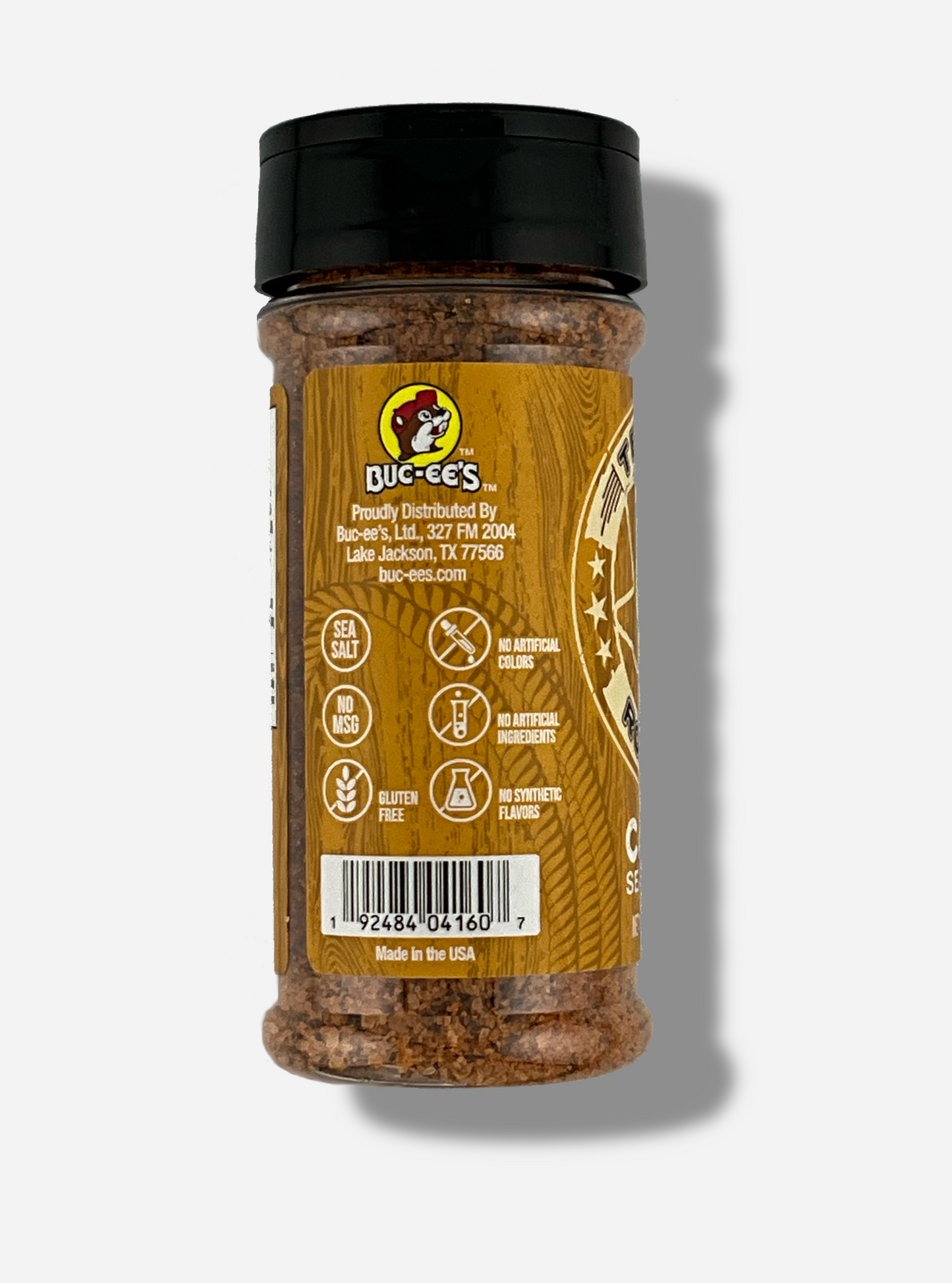 A picture of the side of a container of Texas Round Up Cajun Seasoning. The container has a black plastic flip lid, and a clear plastic body. The spices inside appear orange and black. The tan label reads SEA SALT, NO MSG, GLUTEN FREE, NO ARTIFICIAL COLORS, NO ARTIFICIAL INGREDIENTS, NO SYNTHETIC FLAVORS. Beneath that, MADE IN THE USA.