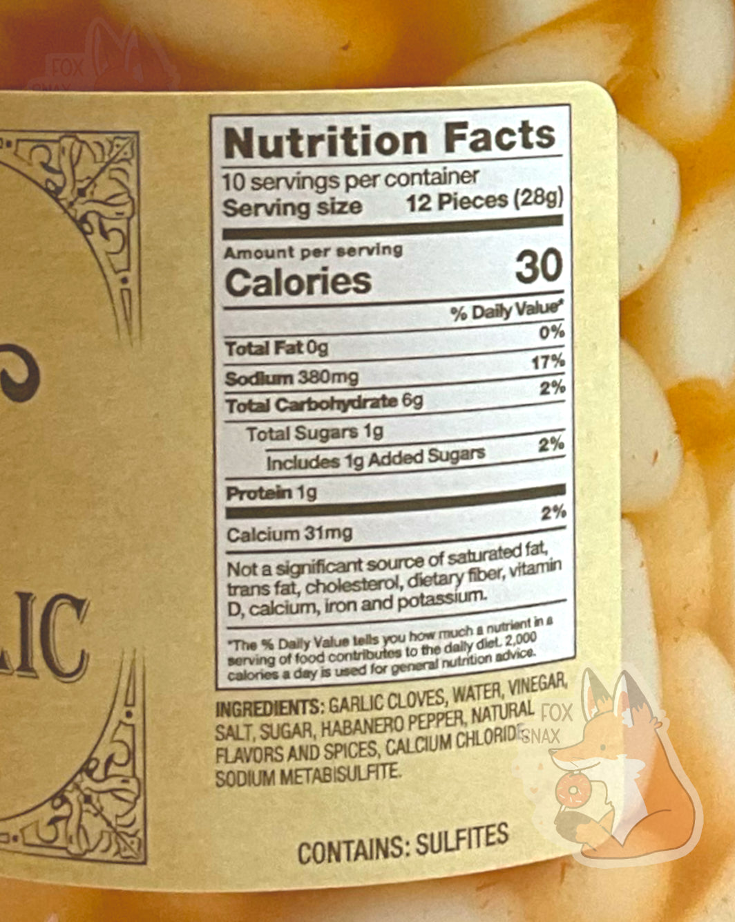 Nutrition facts label on the Picked Habanero Garlic. It reads: NUTRITION FACTS. 10 SERVINGS PER CONTAINER. SERVING SIZE 12 PIECES (28 g). CALORIES 30. TOTAL FAT 0%. SODIUM 17%. TOTAL CARBOHYDRATE 2%
PROTEIN 1g. CALCIUM 31 MG. NOT A SIGNIFICANT SOURCE OF SATURATED FAT, TRANS FAT, CHOLESTEROL, DIETARY FIBER, VITAMIN D, CALCIUM, IRON, AND POTASSIUM. CONTAINS SULFITES. An ingredient list is also displayed.