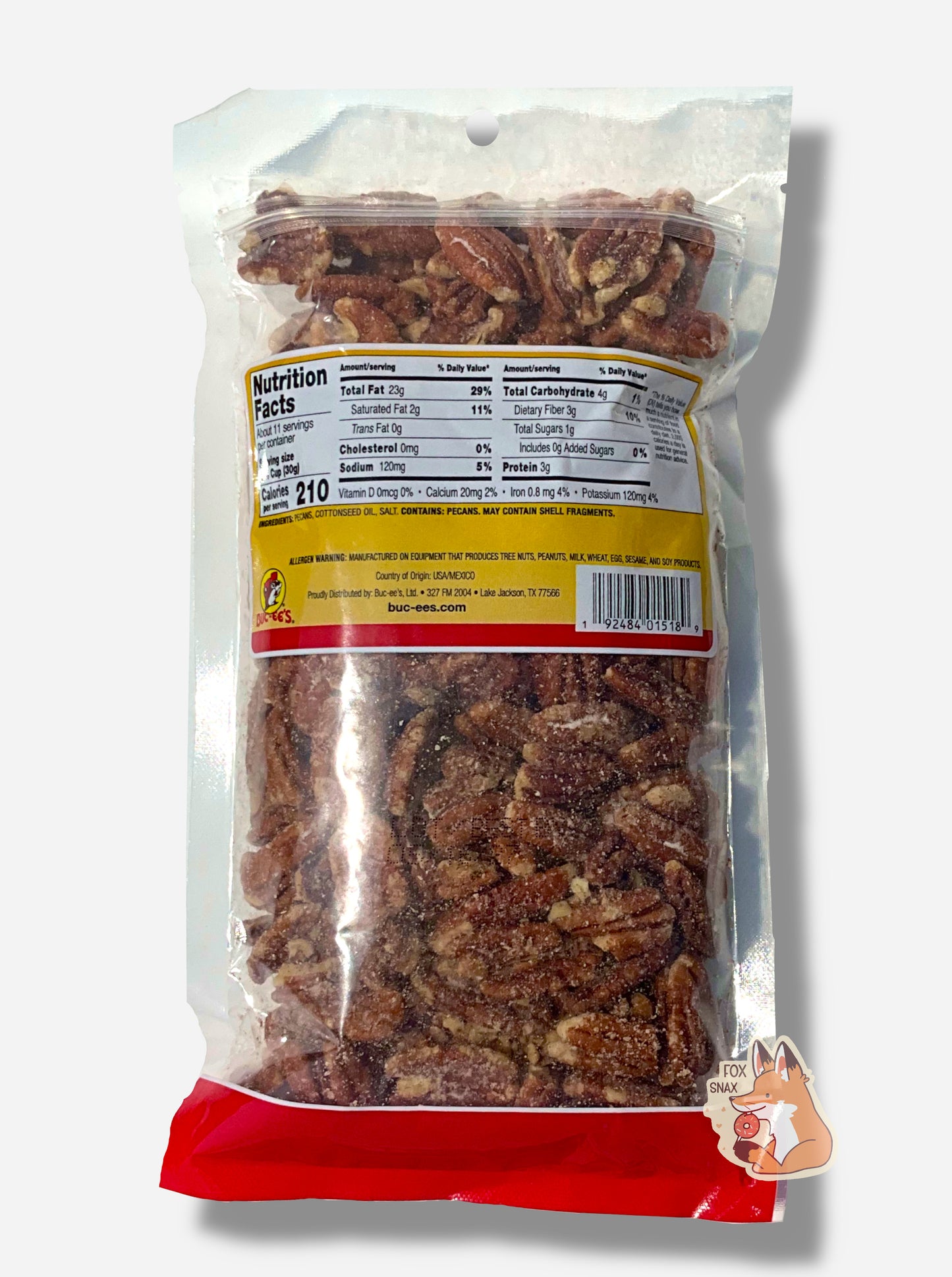 A picture of the back of a clear plastic bag of Buc-ee's Roasted & Salted Pecans. Inside the bag are a large number of dark brown pecans; some grains of salt are on the pecans.