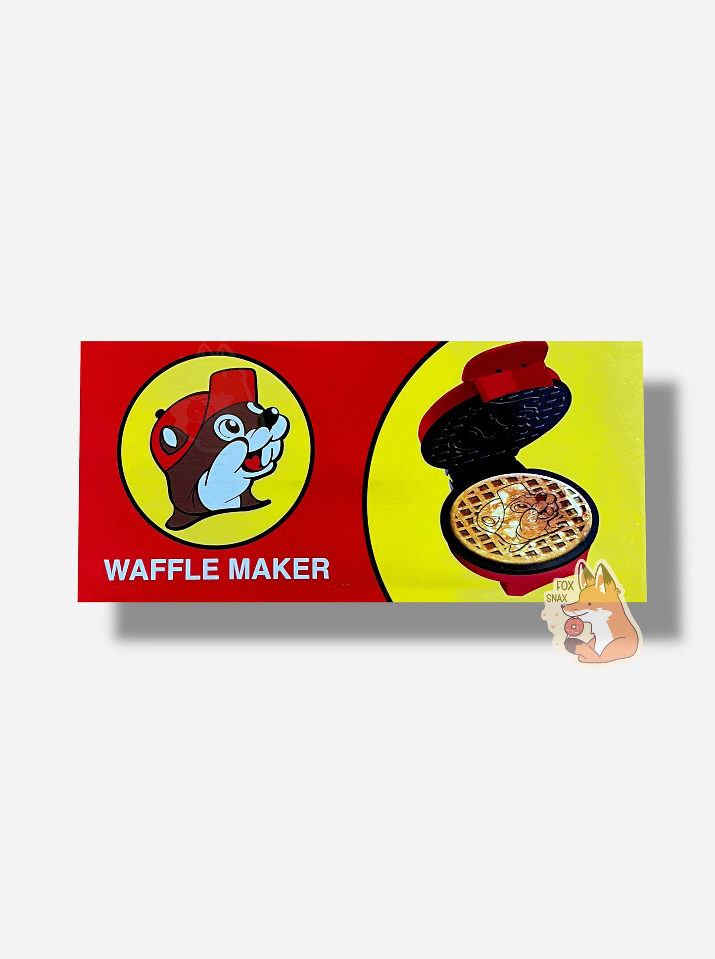 A picture of the top of a rectangular box containing one Buc-ee's Waffle Maker. The box has the Buc-ee's logo in the left, underneath which reads in a white font: WAFFLE MAKER. The right has a picture of the same waffle maker, with a golden brown waffle. The waffle has the Buc-ee's logo in the middle, surrounded by a waffle grid pattern.