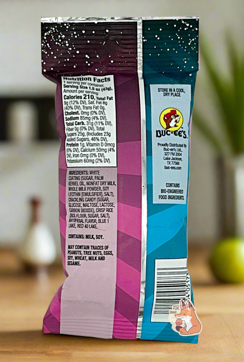 A picture of the back of a bag of Buc-ee's Cosmic Pops, in Cotton Candy flavor. The back of the bag reads STORE IN A COOL, DRY PLACE, then shows a picture of the Buc-ee's beaver logo, then CONTAINS BIO-ENGINEERED FOOD INGREDIENTS. The background is of a kitchen; the bag is resting on a wooden kitchen table.