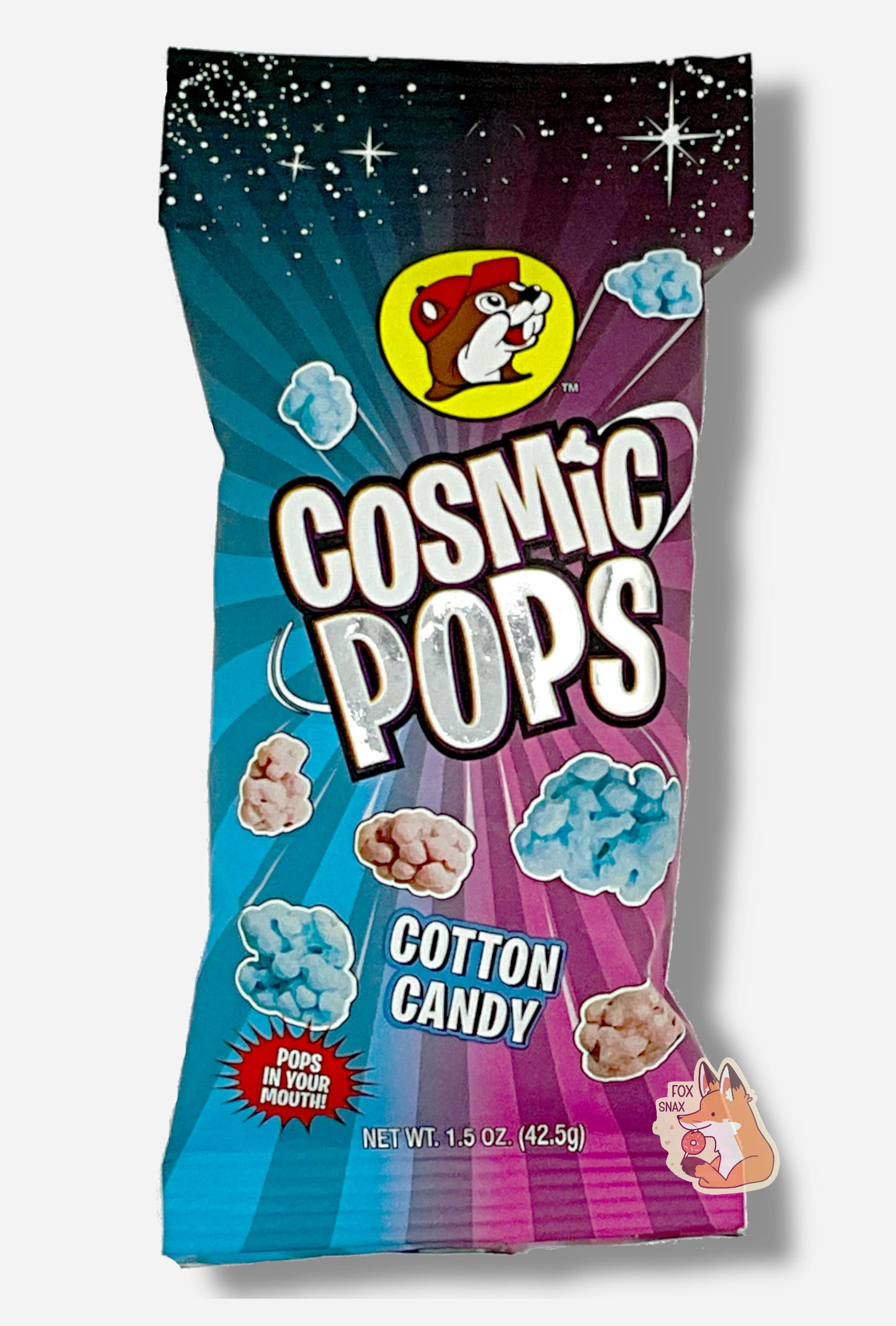 A picture of Buc-ee's Cosmic Pops, in Cotton Candy flavor. The bag starts with stars against a black background at the top, then shows rays of alternating pink and blue colors poking out of the center, to give the impression that the pops - lumpy odd shaped candies - are emerging from the center. A logo on the bottom reads POPS IN YOUR MOUTH!