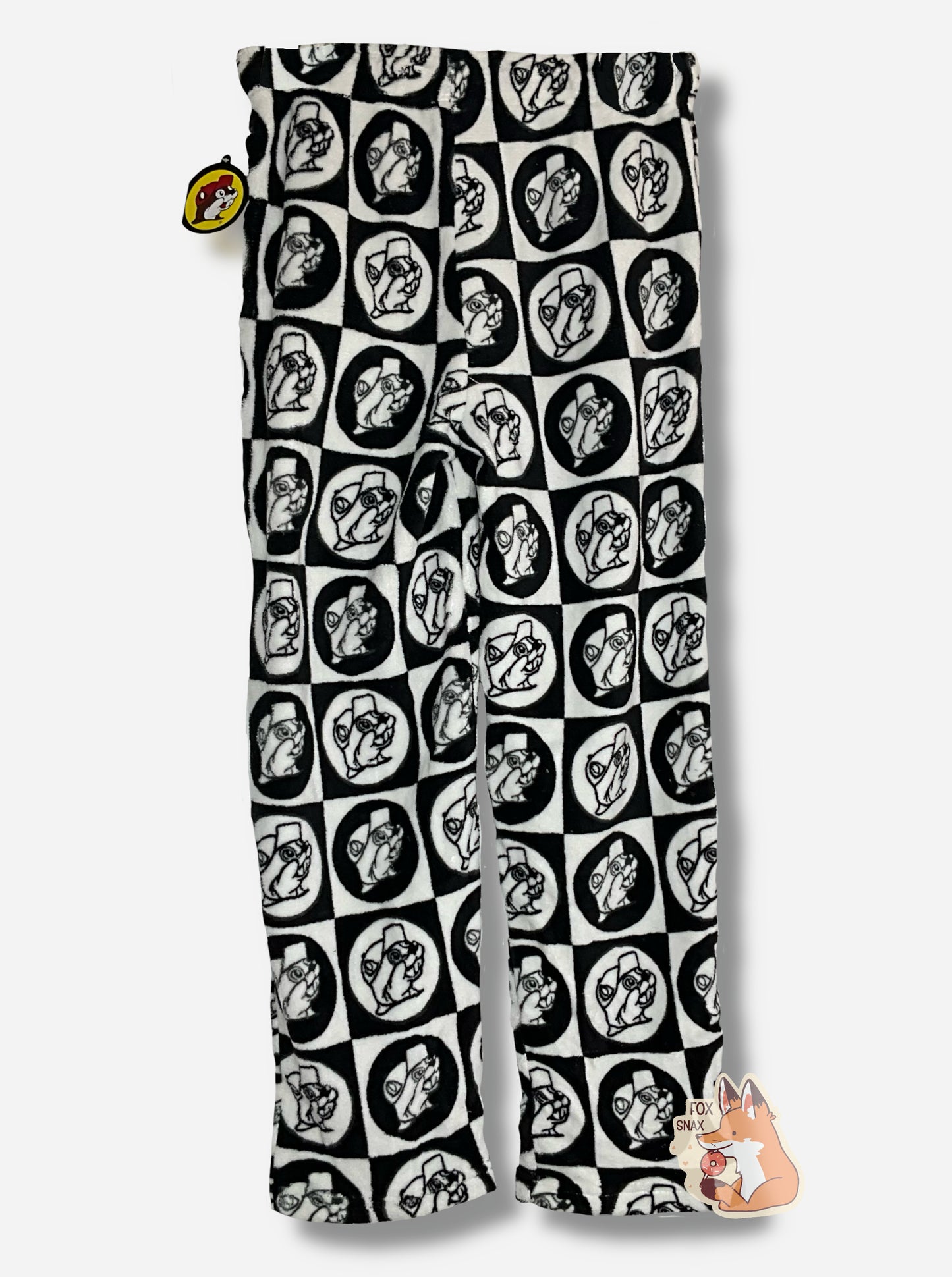 A picture of the back of a pair of fuzzy lounge pants. The pants are black and white; the surface has tons of Buc-ee beaver heads on it, checkered alternately in white and black circles and squares.