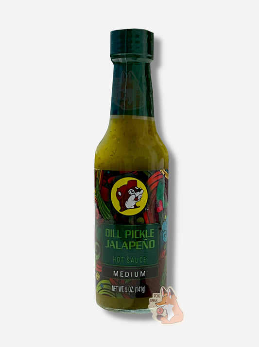 A picture of a small, tall glass bottle of hot sauce.  The top of the bottle is sealed with a dark green plastic cover on a black cap.  The front label of the bottle reads DILL PICKLE JALAPENO, MEDIUM.  The Buc-ee's logo can be seen on the front; the background is a fairly busy abstract artwork featuring several pickles and chilis. The sauce inside is a dark green/green  with smaller green dots.