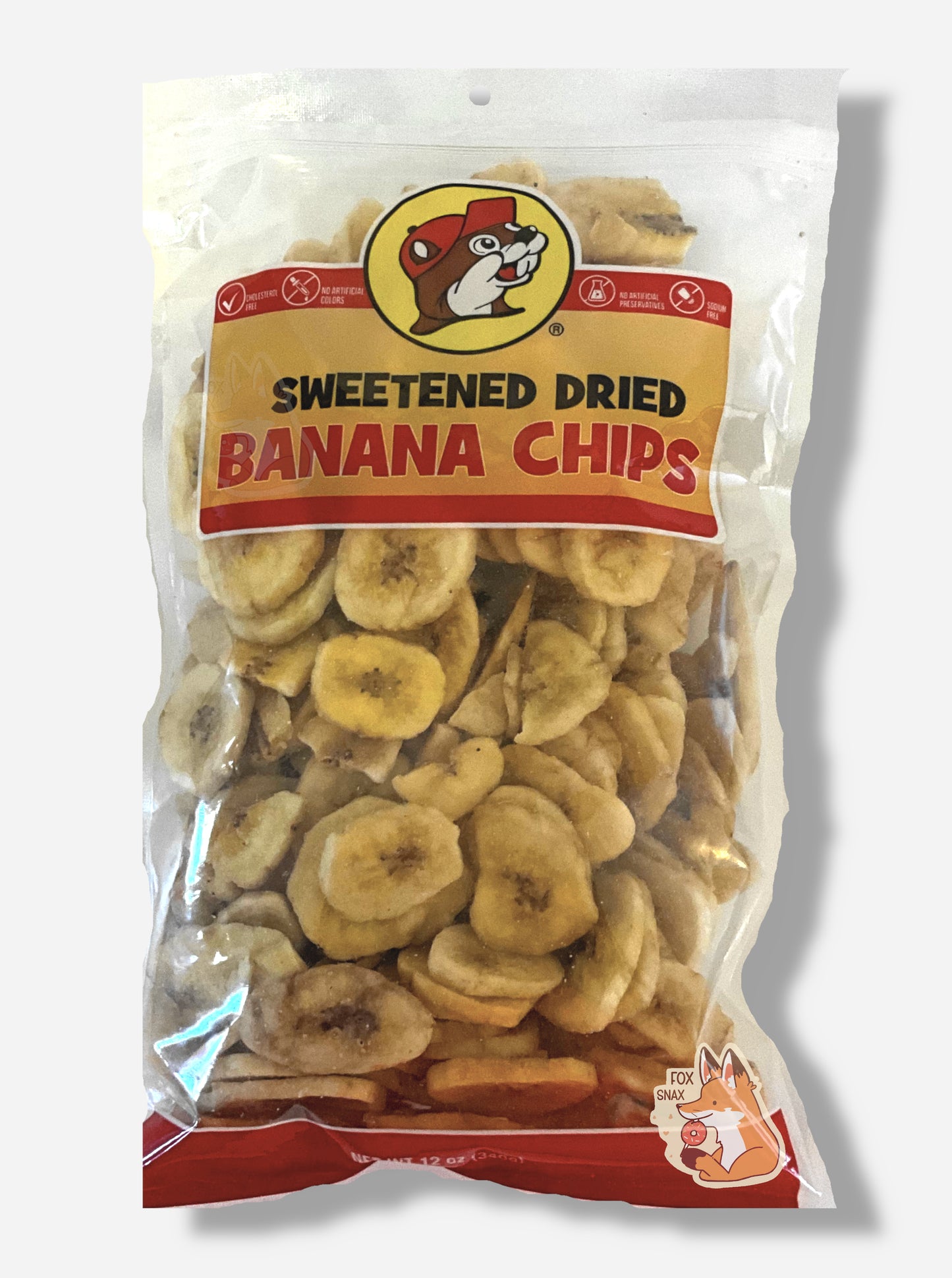 A clear bag of Buc-ee's Sweetened Dried Banana Chips. The top of the bag has the Buc-ee's logo: a cheerful beaver wearing a red ball cap. The middle of the bag is clear, and has a large amount of skinny circular yellow dried banana chips.