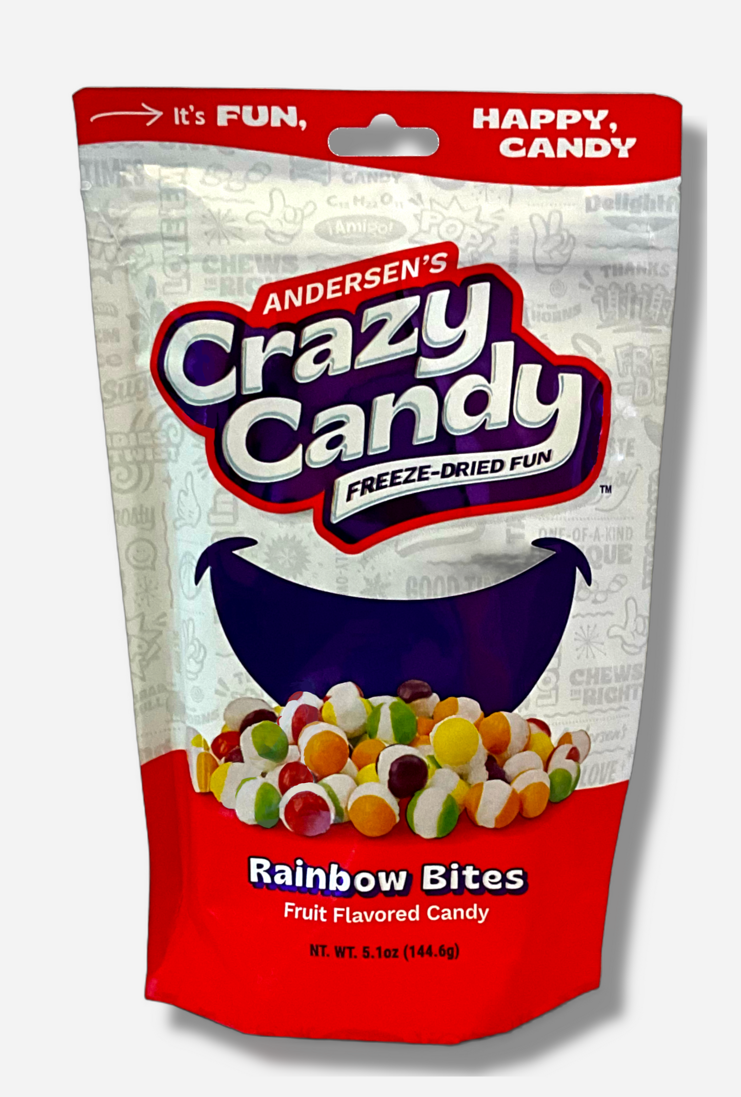 A large bag of Andersen's Crazy Candy Rainbow Bites. The front of the bag also says Freeze-Dried Fun and Fruit Flavored Candy, Net Weight 5.1 oz. It's Fun, Happy, Candy. The top and bottom of the bag are red, and the background is a large purple smile against a white background.