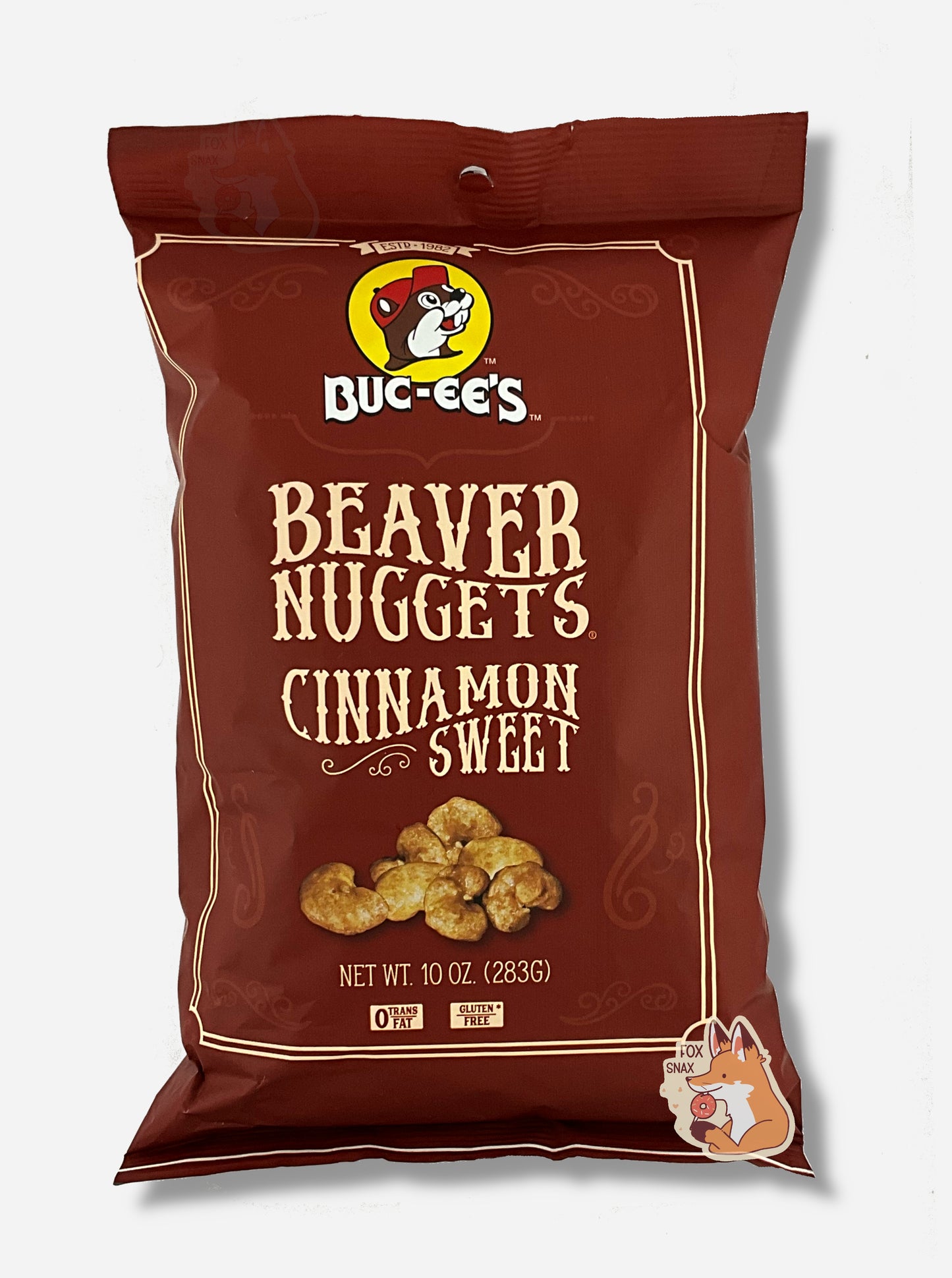 A picture of the front of a opaque, brown bag of Buc-ee's Beaver Nuggets, Cinnamon Sweet. which are puffed corn snack with cinnamon flavors, and has a picture of Buc-ee the Beaver on it. The bag reads: 0 Trans Fat. Gluten Free.