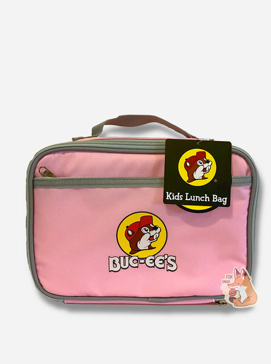 A picture of a front view of a children's lunch box.  The outer surface is made of pink polyester, and has a small grey strap on the top.  The front of the cooler has a picture of the Buc-ee's logo on it: a grinning beaver wearing a red hat against the background of a yellow circle.  Underneath the logo reads BUC-EE'S in white text. The front of the lunch box has a small zip pocket.  The top right of the lunch box has a paper tag that reads KIDS LUNCH BAG.