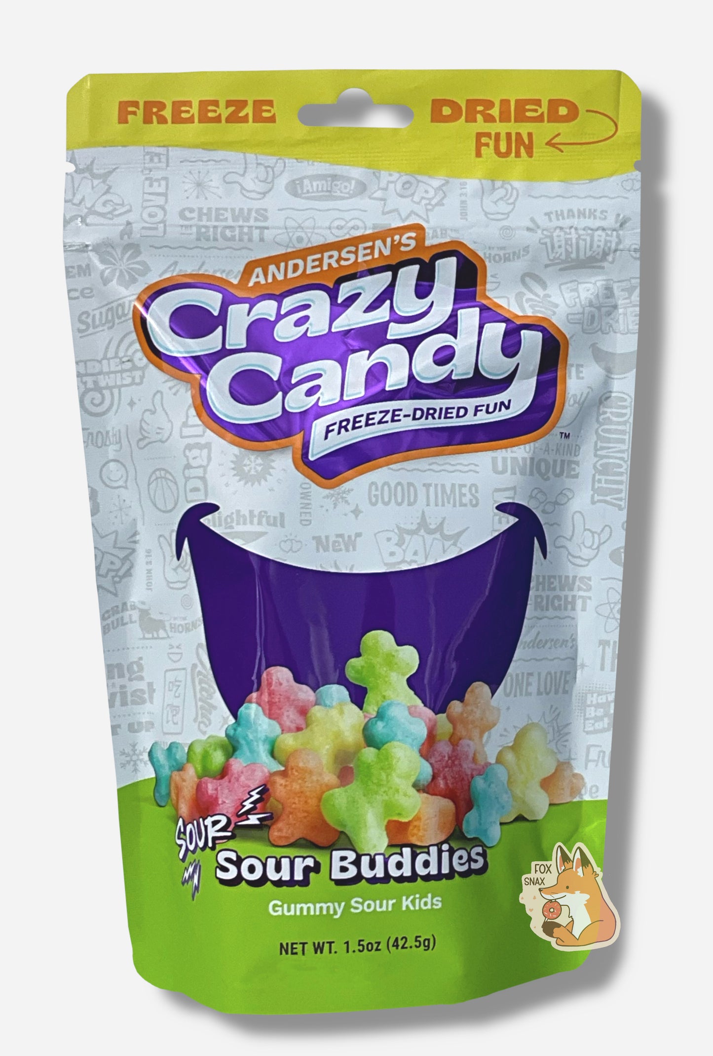 A large bag of Andersen's Sour Buddies The front of the bag also says Gummy Sour Kids, Net Weight 1.5 oz. The top of the bag is yellow, and in red text says "FREEZE DRIED FUN". The middle bottom of the bag shows a large series of puffy, red, orange, yellow, green and blue figures, and the background is a large dark blue smile against a white background with text.