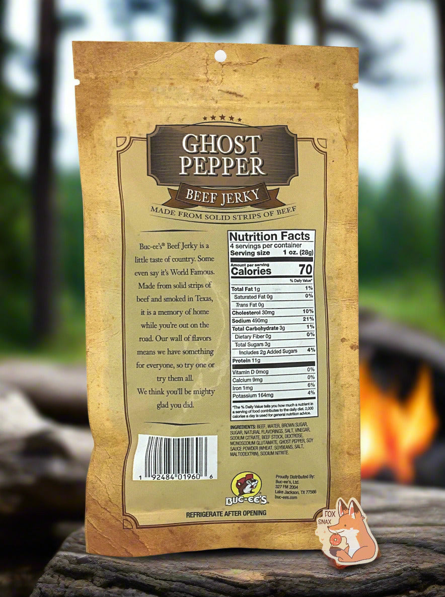 A picture of the back of a tan plastic bag of Buc-ee's Ghost Pepper Beef Jerky. The label underneath reads 'Buc-ee's Beef Jerky is a little taste of country. Some even say it's World Famous. Made from solid strips of beef and smoked in Texas, it is a memory of home while you're out on the road. Our wall of flavors means we have something for everyone, so try one or try them all. We think you'll be mighty glad you did.' In the background, a giant campfire with open flames can be seen.