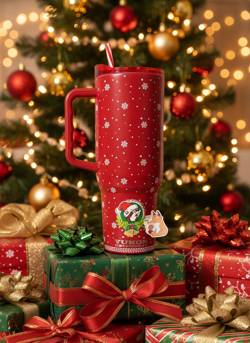 A picture of a tall red, skinny tumbler. The tumbler is paint covering stainless steel. The handle, top, and candy-cane colored straw are red plastic. The background around the text is darker red, with pretty white snowflakes of different sizes all around. The bottom of the tumbler has the Buc-ee's logo; a cheerful brown-furred beaver with a significant overbite. The tumbler is sitting on a pile of presents underneath a Christmas tree decorated with red and yellow ornaments.