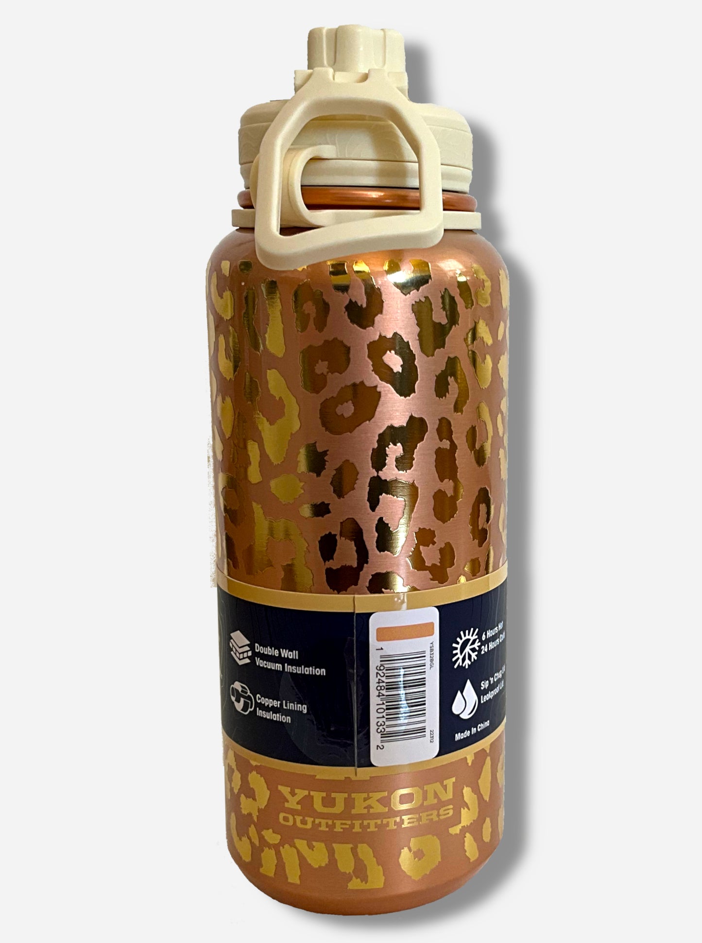 A picture of a tall, metallic, gold leopard print cylindrical water bottle. The surface is spotted like a leopard's hide, alternately dull and bright gold, as it is covering stainless steel. There is no handle. The top is a screw on plastic knob with a keychain handle. Underneath the paper label, engraved text on the bottom reads: YUKON OUTFITTERS.