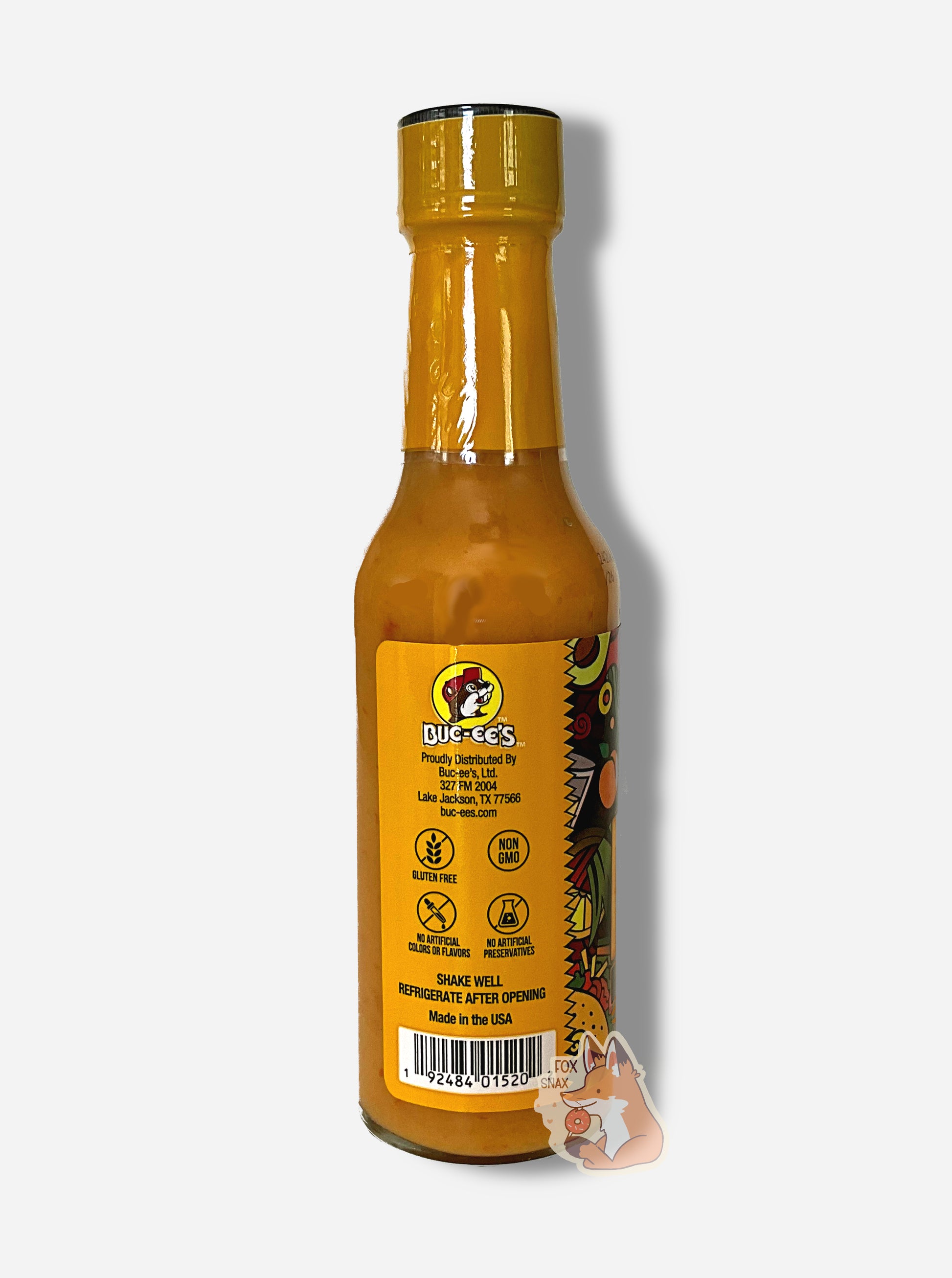 A picture of a small, tall glass bottle of hot sauce. The top of the bottle is sealed with a plastic top.  The back reads GLUTEN FREE, NON GMO, NO ARTIFICIAL COLORS OR FLAVORS, NO ARTIFICIAL PRESERVATIVES, then SHAKE WELL and REFRIGERATE AFTER OPENING.  Made in the USA.  The sauce inside is bright orange.