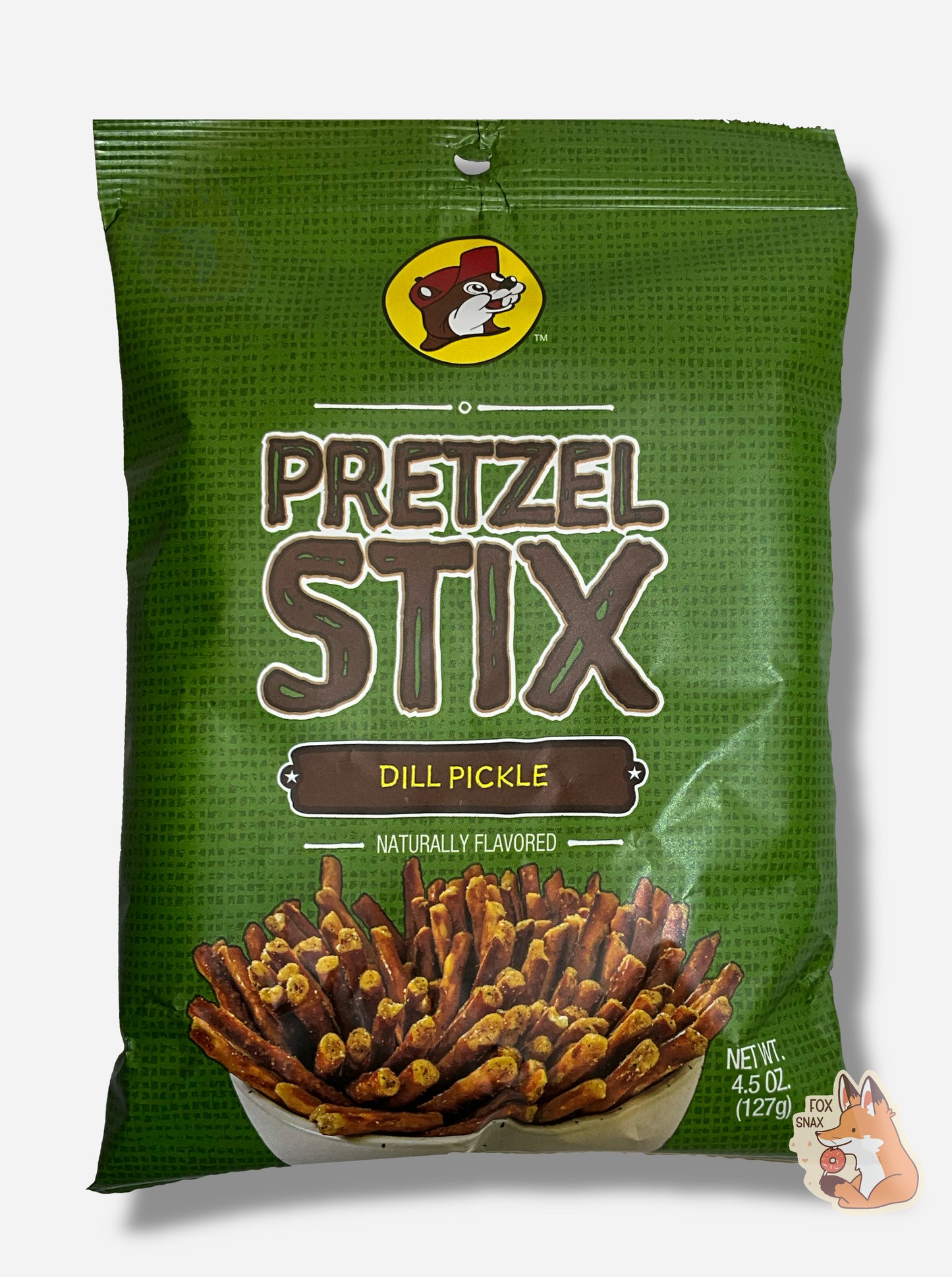 A picture of the front of a green bag of Buc-ee's Pretzel Stix, Dill Pickle flavor. The bag reads NATURALLY FLAVORED. At the top is the Buc-ee's logo - a cheerful beaver wearing a red ball cap. The middle reads PRETZEL STIX in a brown font, then DILL PICKLE, then NATURALLY FLAVORED. A large white bowl containg a plethora of coated pretzel sticks is on the bottom.