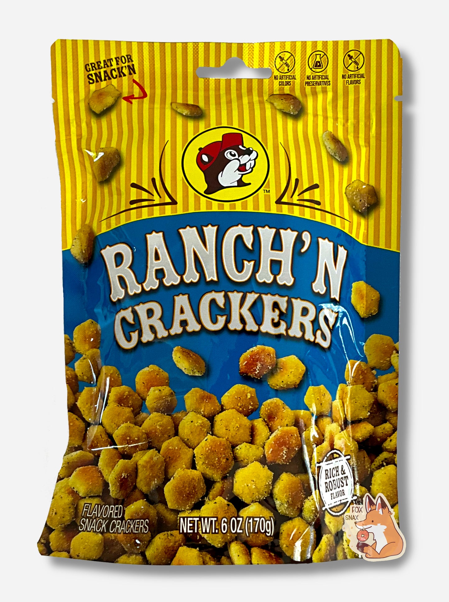 A picture of a metallic bag of Buc-ee's Ranch'N Crackers. The logo is a blue background on white text; a large number of tan, savory-looking hexagonal oyster crackers are shown beneath it. At the top is a picture of the logo of Buc-ee The Beaver, and it reads GREAT FOR SNACK'N, NO ARTIFICIAL COLORS, PRESERVATIVES, FLAVORS