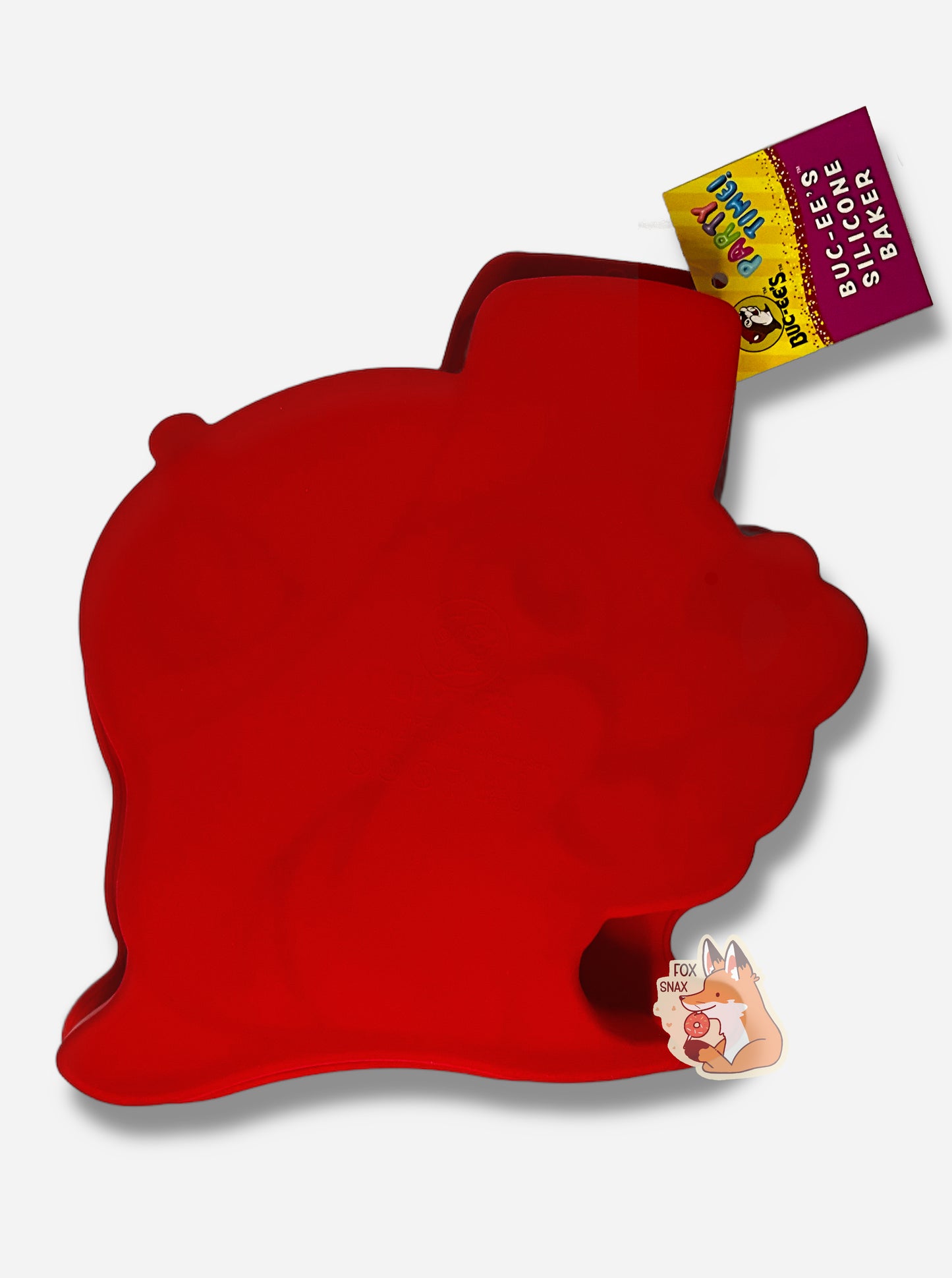 A picture of the back of a bright red, floppy, silicone baking tray. The tray is shaped like Buc-ee The Beaver's Head. The tag attached to the tray reads PARTY TIME! BUC-EE's SILICONE BAKER