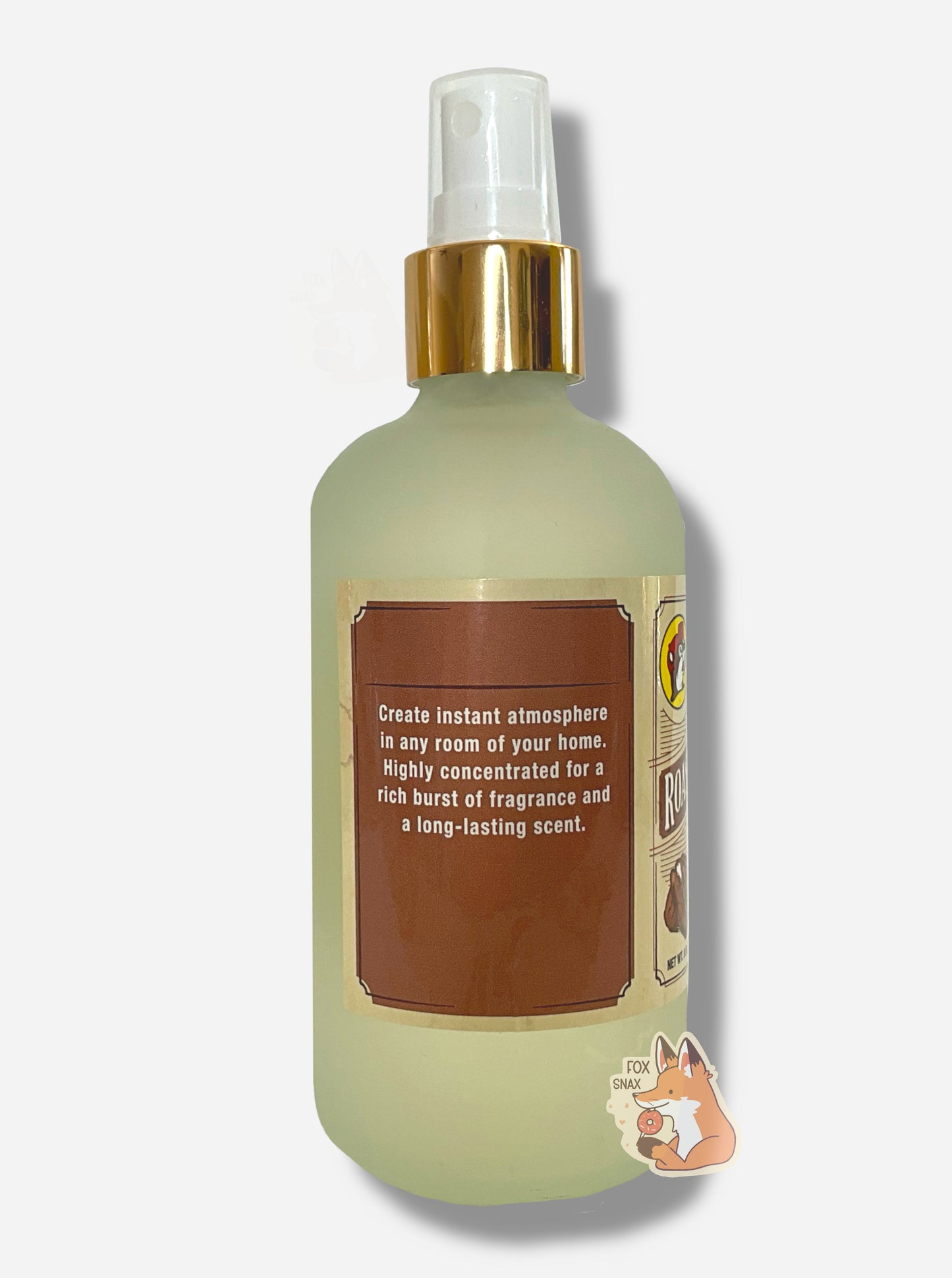 Right side of spray bottle of Buc-ee's Roasted Pecans Freshening Room Mist on a white background. The bottle is frosted glass with a white sprayer and gold label. The label reads: Create instant atmosphere in any room of your home. HIghly concentrated or a rich burst of fragrance and a long-lasting scent.