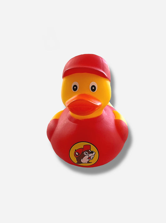 A picture of the front of a yellow rubber duck.  The duck has an orange beak, and is made of plastic.  It is wearing a red ball cap on its head, and a red t-shirt around its body.  The front of the t-shirt has the Buc-ee's logo: a cheerful, brown furred beaver with a significant overbite, which is wearing a red ball cap.