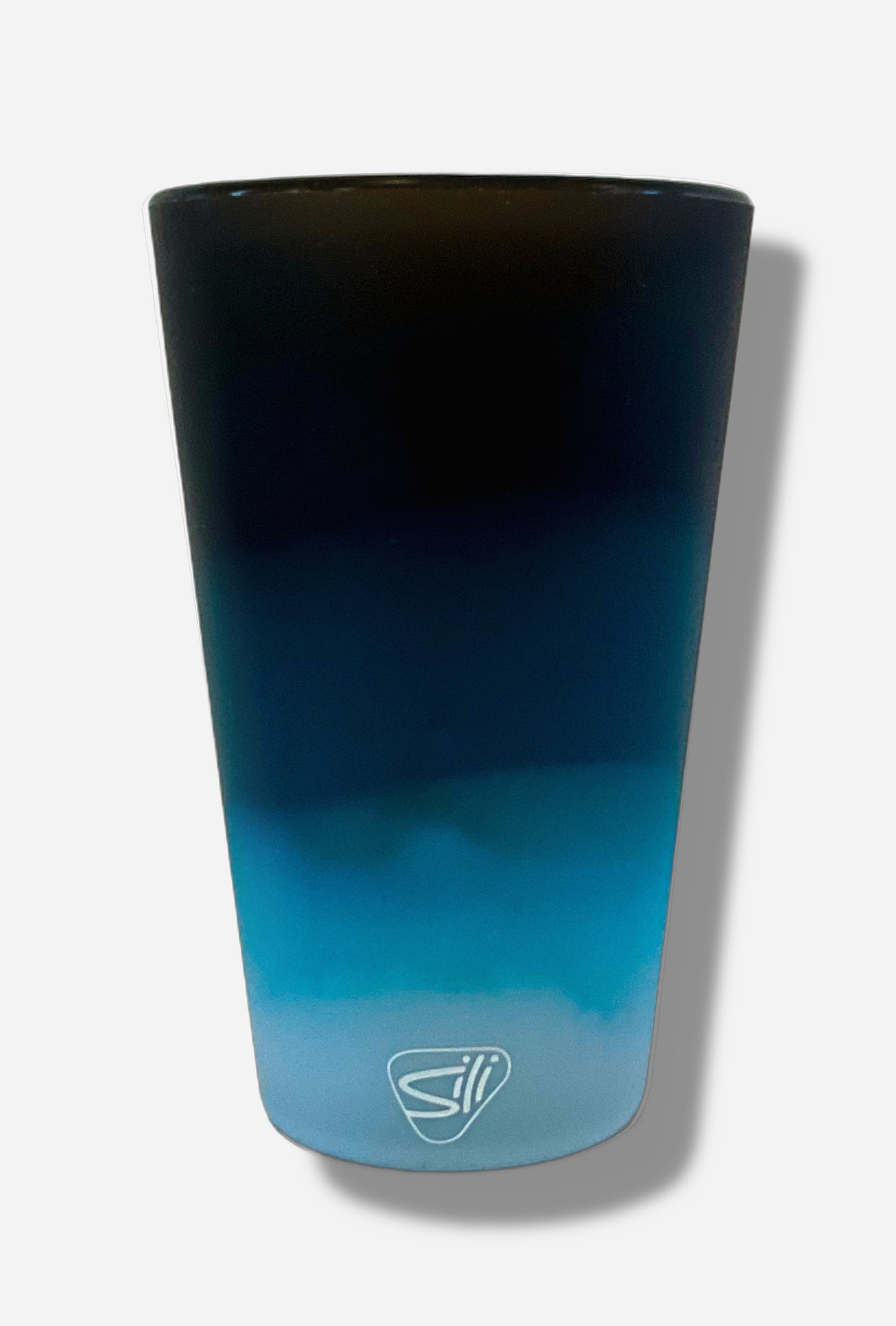 A picture of the back of silicone pint glass. The glass is a very light blue at the bottom, and via a "cloud-like" gradient, transitions to dark blue at the top. There is a small white 'sili' logo on the bottom of the glass.
