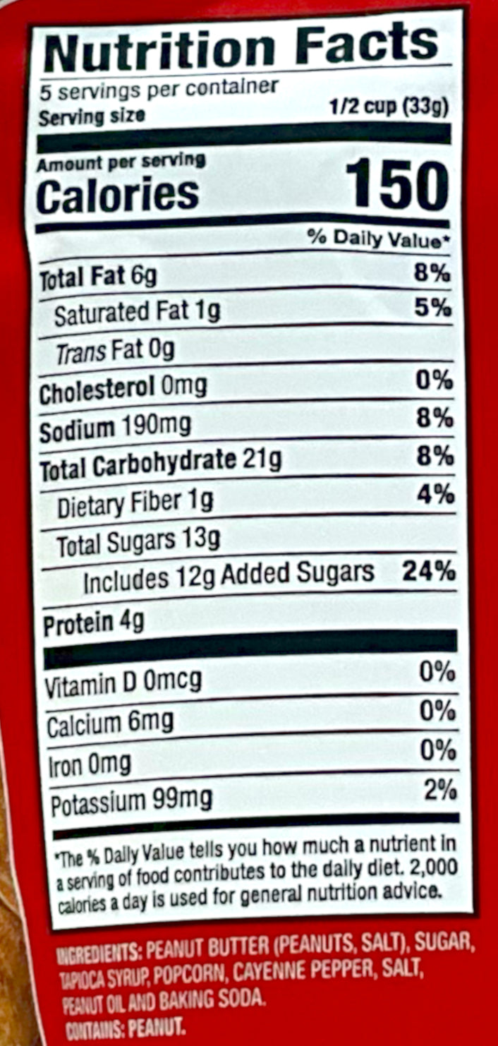 A closeup of the back of a red bag of Buc-ee's Spicy Peanut Butter & Caramel Popcorn. Nutrition facts, and ingredients, are listed.