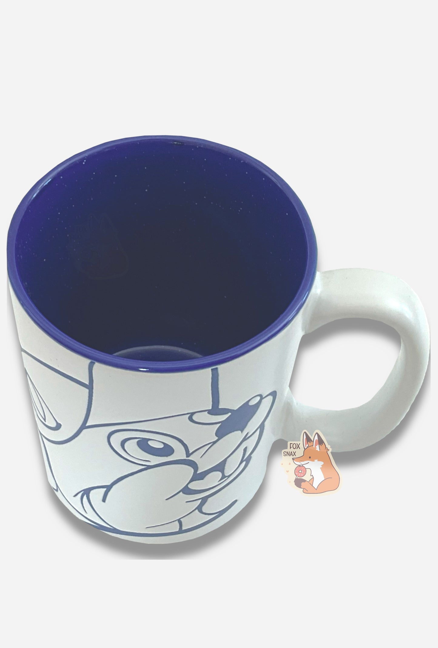 A picture of a ceramic, dark blue and white coffee mug. The mug prominently features a picture of Buc-ee The Beaver on the front and back, in dark blue. The interior of the mug is a dark blue as well, and rest of the mug is white.