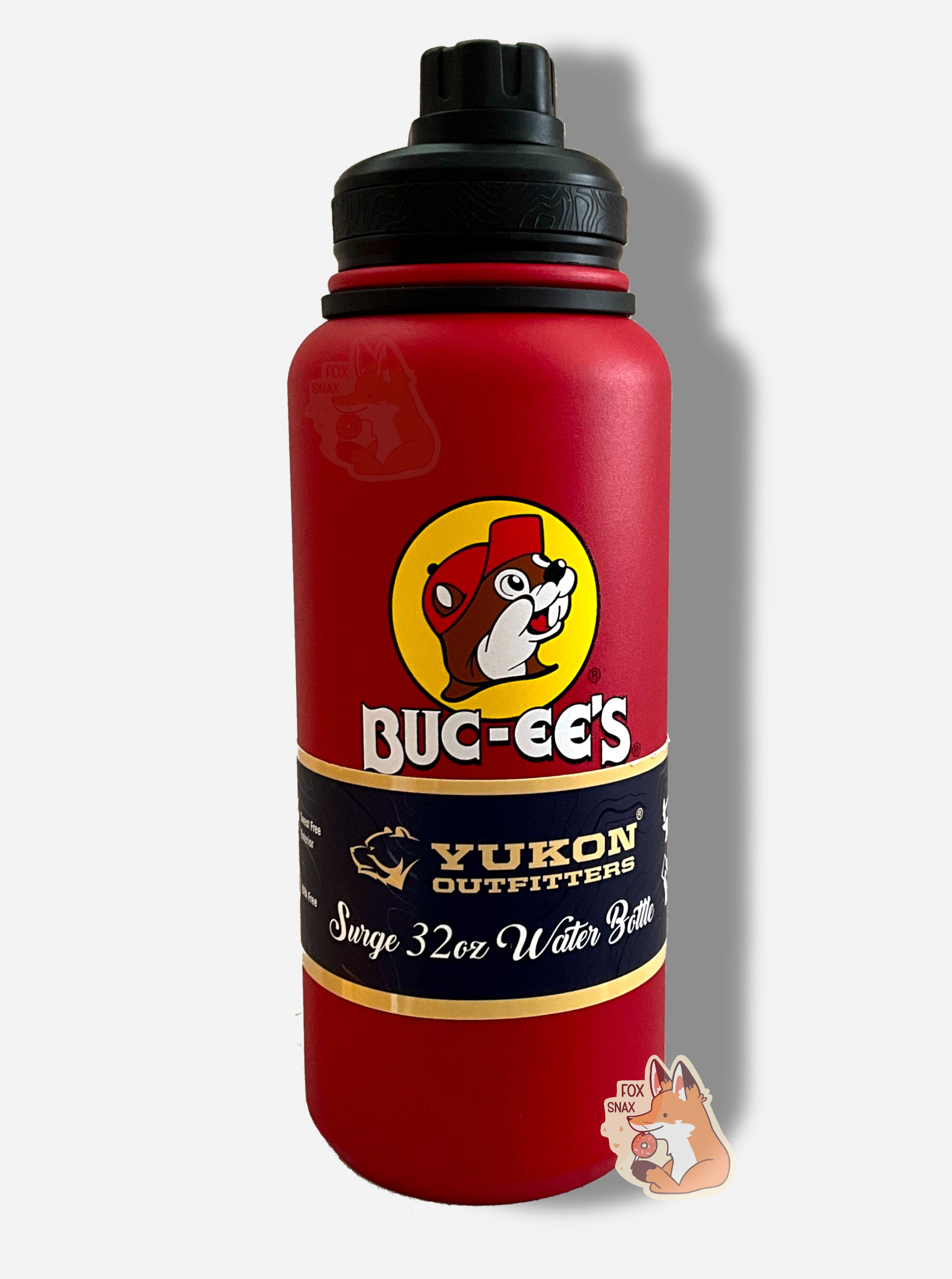 A picture of a tall red cylindrical water bottle, with a big picture of Buc-ee The Beaver on it.  The surface is smooth and red, as it is red paint covering stainless steel.  There is no handle.  The top is a screw on plastic knob with a keychain handle.  A paper wrapper around the bottom reads: Yukon Outfitters.  Surge 32 oz Water Bottle.