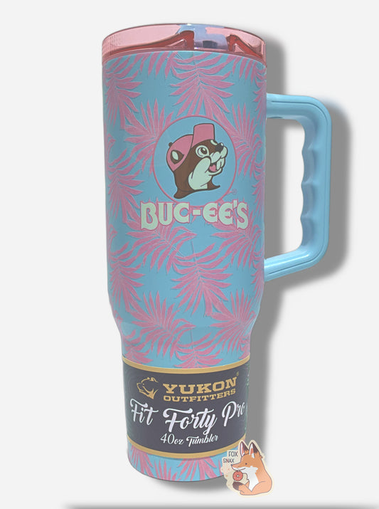 A picture of a tall, light blue, sorta skinny tumbler, with a big picture of Buc-ee The Beaver on it.  Buc-ee's hat, and the circle behind him, is in light pink.  The surface is light blue, and covered in light pink palm fronds.  It is matte paint in covering stainless steel.  The handle and sipper on top of the lid are light blue.  The top is light transparent pink plastic.  A paper wrapper around the bottom reads: Yukon Outfitters.  Fit Forty Pro 40 oz Tumbler.