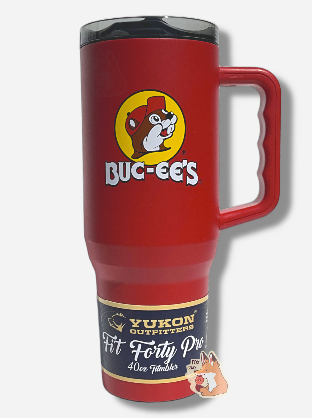 A picture of a tall, red, sorta skinny tumbler, with a big picture of Buc-ee The Beaver on it, framed in a large yellow circle.  The surface is smooth and red, as it is red paint covering stainless steel.  The handle and top are plastic - the handle red, the top dark but clear.  A paper wrapper around the bottom reads: Yukon Outfitters.  Fit Forty Pro 40 oz Tumbler.