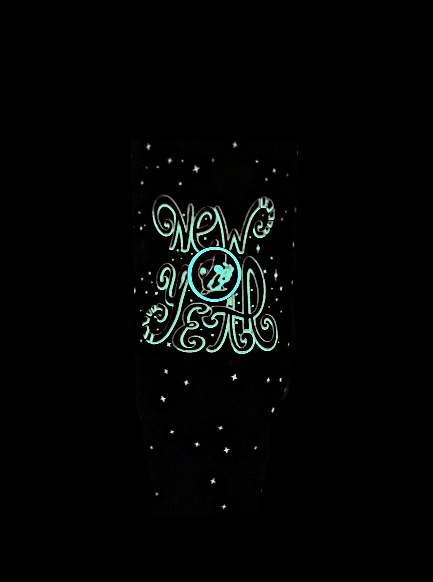 A picture of a glowing green Buc-ee's New Year tumbler.  The background is solid black.  A glowing green set of text in curly font reads NEW YEAR.  In the middle of NEW and YEAR is the Buc-ee's logo, also glowing in green.  Some of the stars and dots on the tumbler are glowing green as well, surrounding the text.