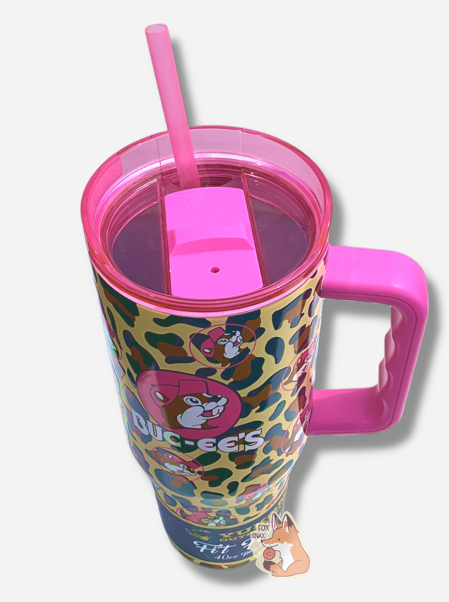 A three quarters view  of a tall, pink and leopard print, sorta skinny tumbler, with a big picture of Buc-ee The Beaver on it.  Buc-ee's hat, and the circle behind him, is in hot pink.  The surface is a leopard print, as it is matte paint in leopard colors covering stainless steel.  The handle, top, and straw are hot pink and plastic.  A paper wrapper around the bottom reads: Yukon Outfitters.  Fit Forty 40 oz Tumbler.