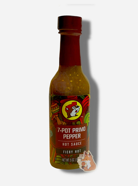A picture of a small, tall glass bottle of hot sauce.  The top of the bottle is sealed with a plastic top.  The front label of the bottle reads 7-POT PRIMO PEPPER HOT SAUCE, FIERY HOT.  The Buc-ee's logo can be seen on the front; the background is a fairly busy abstract artwork featuring a heart, two maracas, and various colorful swooshes.  The sauce inside is a yellow/tan color, with pepper seeds visible.