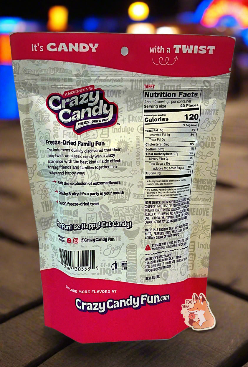 The back of a large bag of Andersen's Crazy Candy Taffy.  The bag reads: Freeze Dried Family Fun.  The Andersens quickly discovered that their funky twist on classic candy was a crazy experience with the best kind of side effect: bringing friends and families together in a unique and happy way!.  The bag is sitting on a beach boardwalk at night; pretty multicolored chain lights can be seen in the background.
