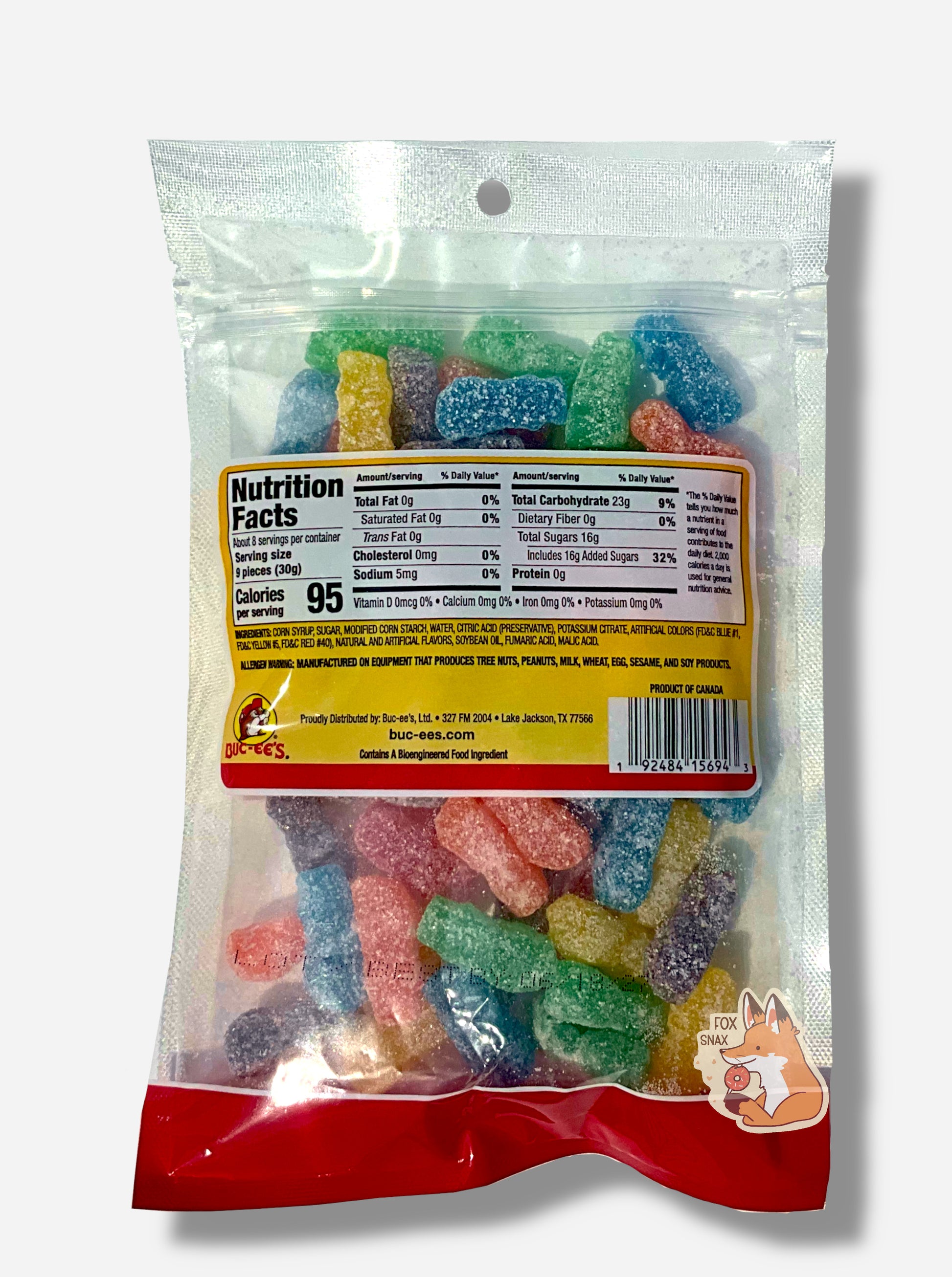 A picture of the back of a clear resealable bag of Buc-ee's Original Sour Crew, which are red, orange, yellow, green, blue, and purple sour and sweet sorta-human-shaped candies.  The bag reads ORIGINAL SOUR CREW, Naturally & Artificially Flavored, and has a picture of Buc-ee the Beaver on it.  The candies inside are coated in large white grains of sugar and sour powder.  Nutrition facts, then ingredients, can be seen.