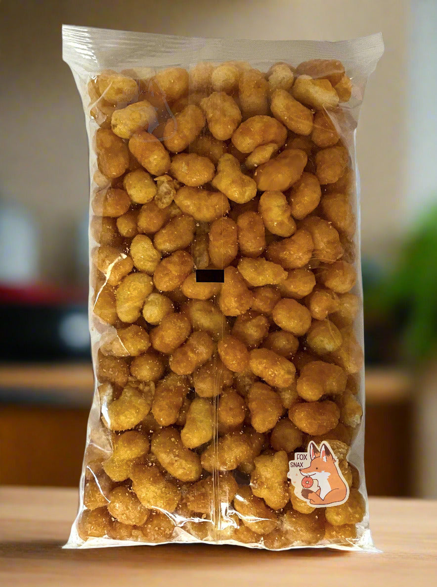 A picture of the back of a clear plastic bag of Buc-ee's Beaver Nuggets, which are a puffed corn snack with caramel flavors.  The nuggets are sitting on a kitchen countertop.