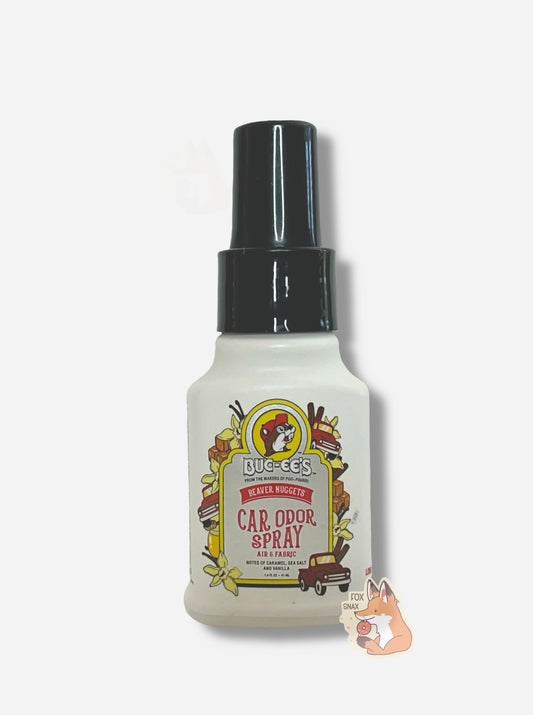 Front of a white bottle of Buc-ee's car odor spray on a white background.  The label reads Beaver Nuggets Car Odor Spray, Air & Fabric, Notes of Caramel, Sea Salt, and Vanilla, then 1.4 FL OZ.  The text is surrounded by the Buc-ee's logo, vanilla flowers, caramels, red trucks, and vanilla beans.  