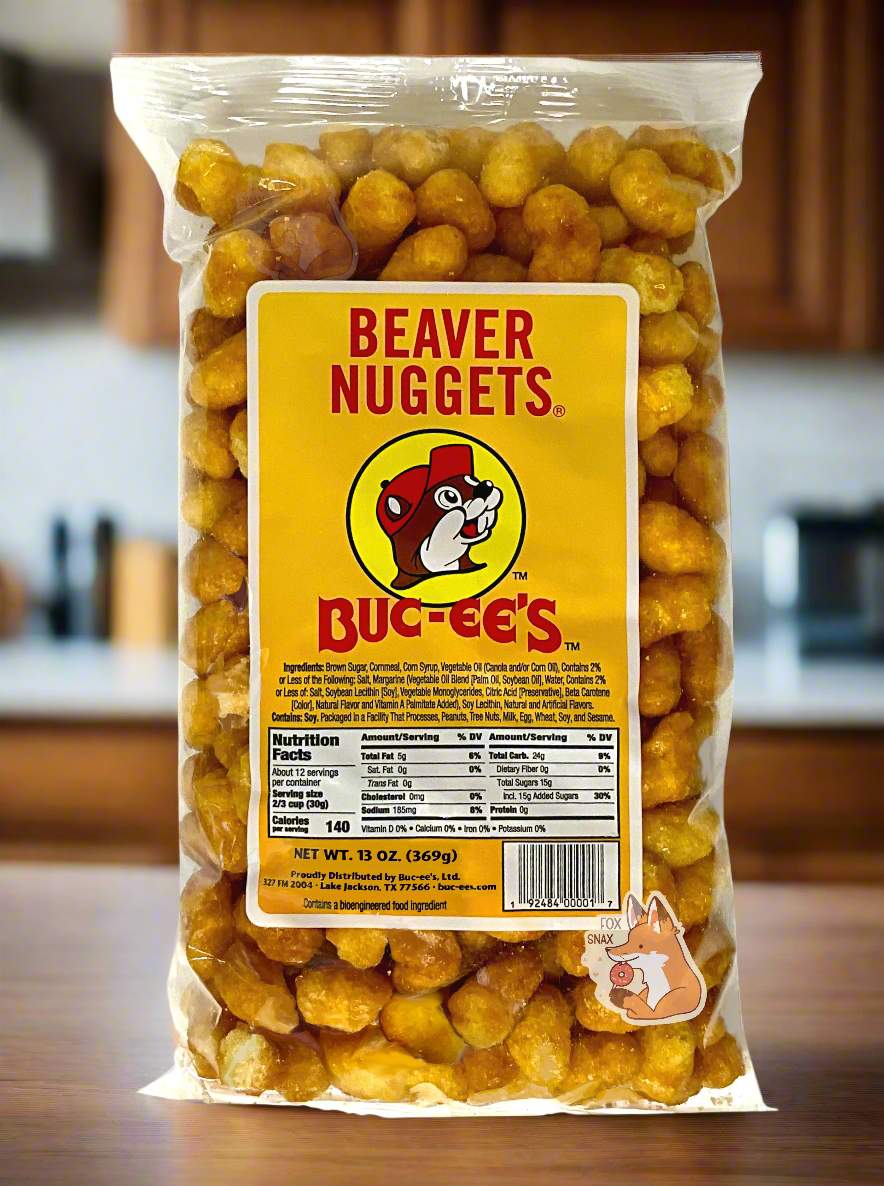 A picture of the front of a clear plastic bag of Buc-ee's Beaver Nuggets, which are puffed corn snack with caramel flavors, and has a picture of Buc-ee the Beaver on it.  The nuggets are sitting on a kitchen countertop.