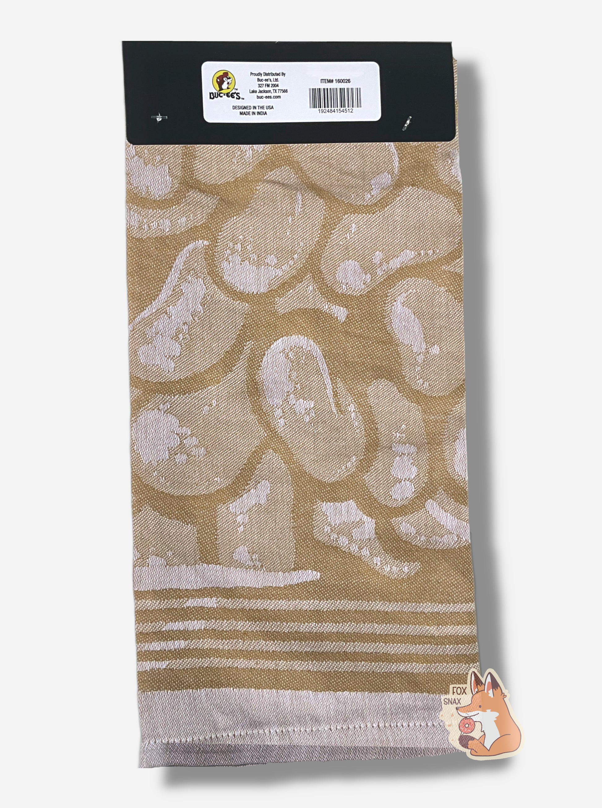 A picture of the back of a 20x28, tan kitchen towel, covered in images of beaver nuggets.  The full unwrapped towel shows a large rectangular package of Beaver Nuggets.  