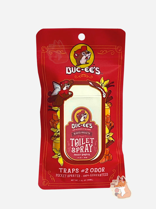 Red package of Buc-ee's toilet spray on a white background.  The label, amusingly, in the top left, has Buc-ee with a pair of angel wings, holding a roll of toilet paper in one paw, and in the other, outraised, throwing a roll of toilet paper.  The label reads: BUC-EE'S, FROM THE MAKERS OF POO~POURRI, BEAVER NUGGETS POCKET TOILET SPRAYER, then TRAPS #2 ODOR, then 1 FL OZ