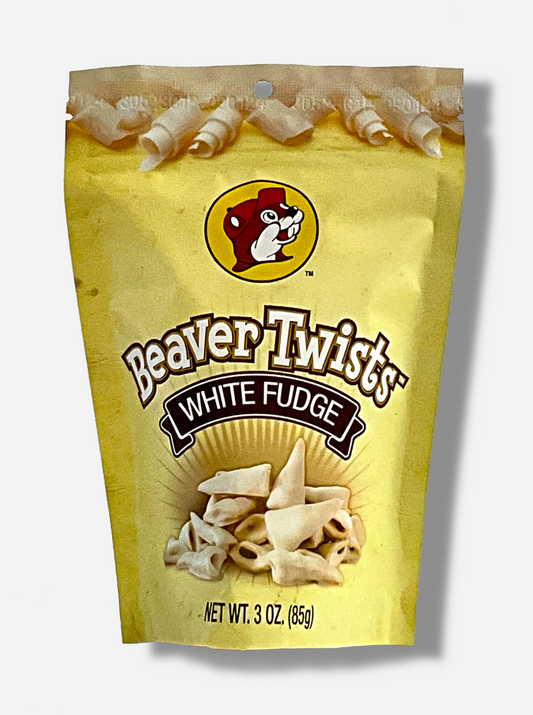 A picture of a slightly metallic yellow bag, with the Buc-ee's logo on it, which is a cheerful beaver wearing a red hat against a yellow circle.  Beneath the icon reads the text BEAVER TWISTS WHITE FUDGE.  The top of the bag has pictures of curls of white fudge, the bottom of the bag has pictures of the twists themselves: cone-shaped corn treats covered in white fudge.