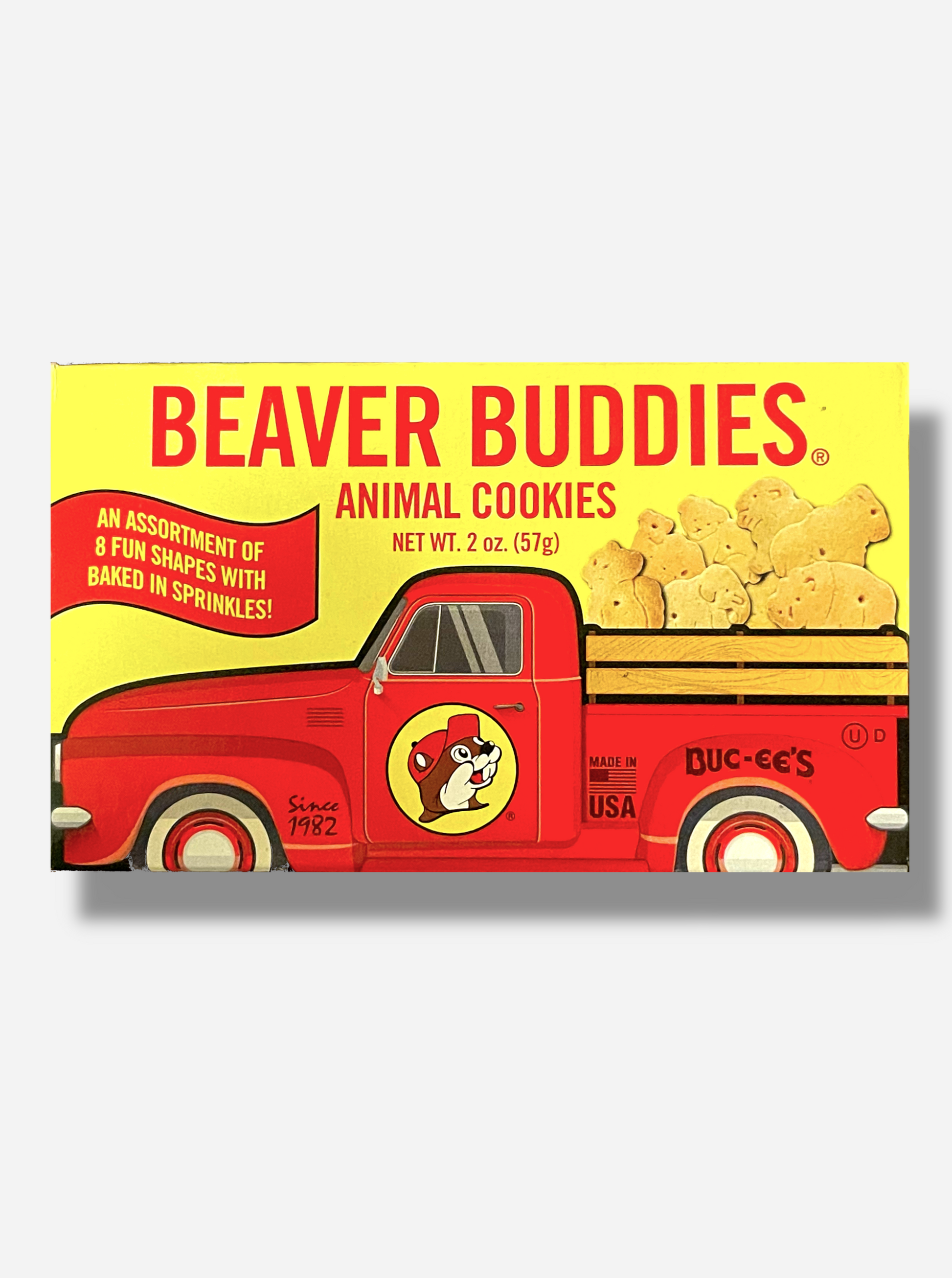 The back of a small rectangular cardboard package of Buc-ee's Beaver Buddies Animal Cookies.  The label has a picture of a red truck with the Buc-ee The Beaver logo on the door panel, and a series of animal cookies in the bed of the truck.  The text reads BEAVER BUDDIES ANIMAL COOKIES, NET WT 2 oz (57g).  AN ASSORTMENT OF 8 FUN SHAPES WITH BAKED IN SPRINKLES!  Made in the USA.