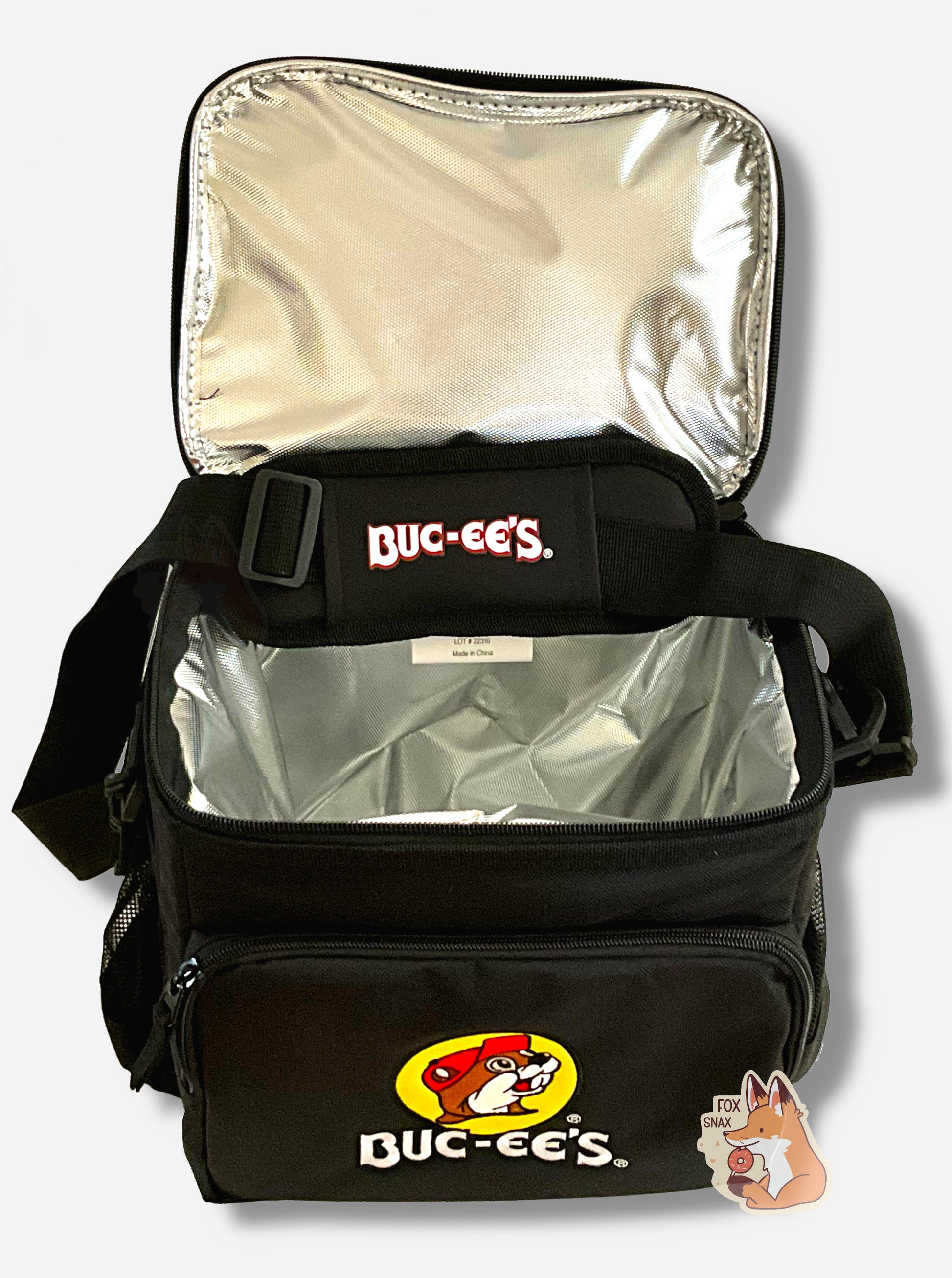 A picture of the front of a large lunch box cooler.  The outer surface is made of black polyester, and has a large black strap on it that reads BUC-EE'S.  The front of the total has a zip pouch, with the Buc-ee's logo on it: a grinning beaver wearing a red hat against the background of a yellow circle.  The sides of the tote has mesh pouches, the top opened to show the liner, a foil composite inside.
