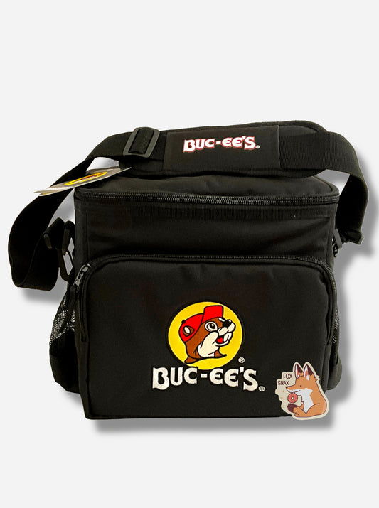 A picture of a three-quarters view of the front of a lunch box cooler.  The outer surface is made of black polyester, and has a large black strap on it that reads BUC-EE'S.  The front of the lunch box has a zip pouch, with the Buc-ee's logo on it: a grinning beaver wearing a red hat against the background of a yellow circle.  The sides of the tote has mesh pouches, the top sealed by a zipper.