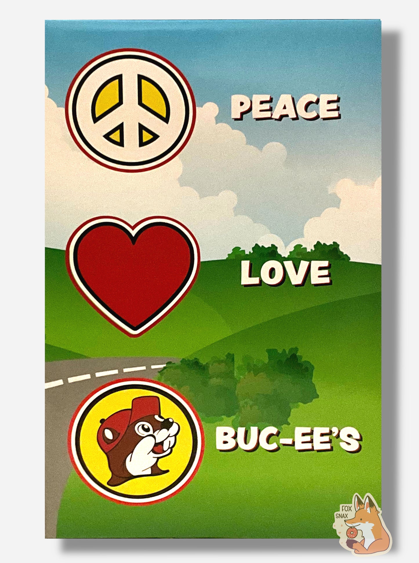 A picture of the back side of a box for a Buc-ee The Beaver Bobblehead.  It shows a cartoon meadow with a road leading behind a hill.  In large white text, it states PEACE (next to a peace sign), LOVE (next to a heart sign), and BUC-EE'S (next to a logo of Buc-ee The Beaver)