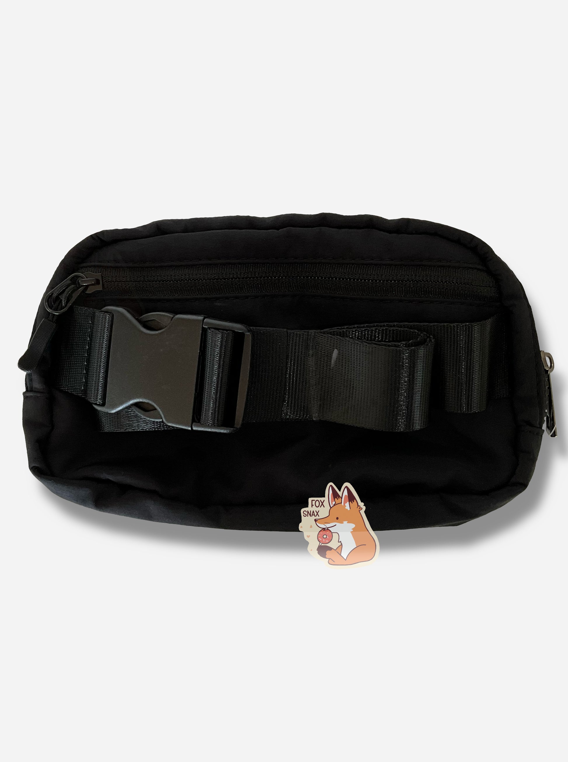 A picture of an oblong, black fanny pack, with a black zipper on the back.  The back also shows a large black strap hooked into each side of the pack, with a plastic clip in the middle.