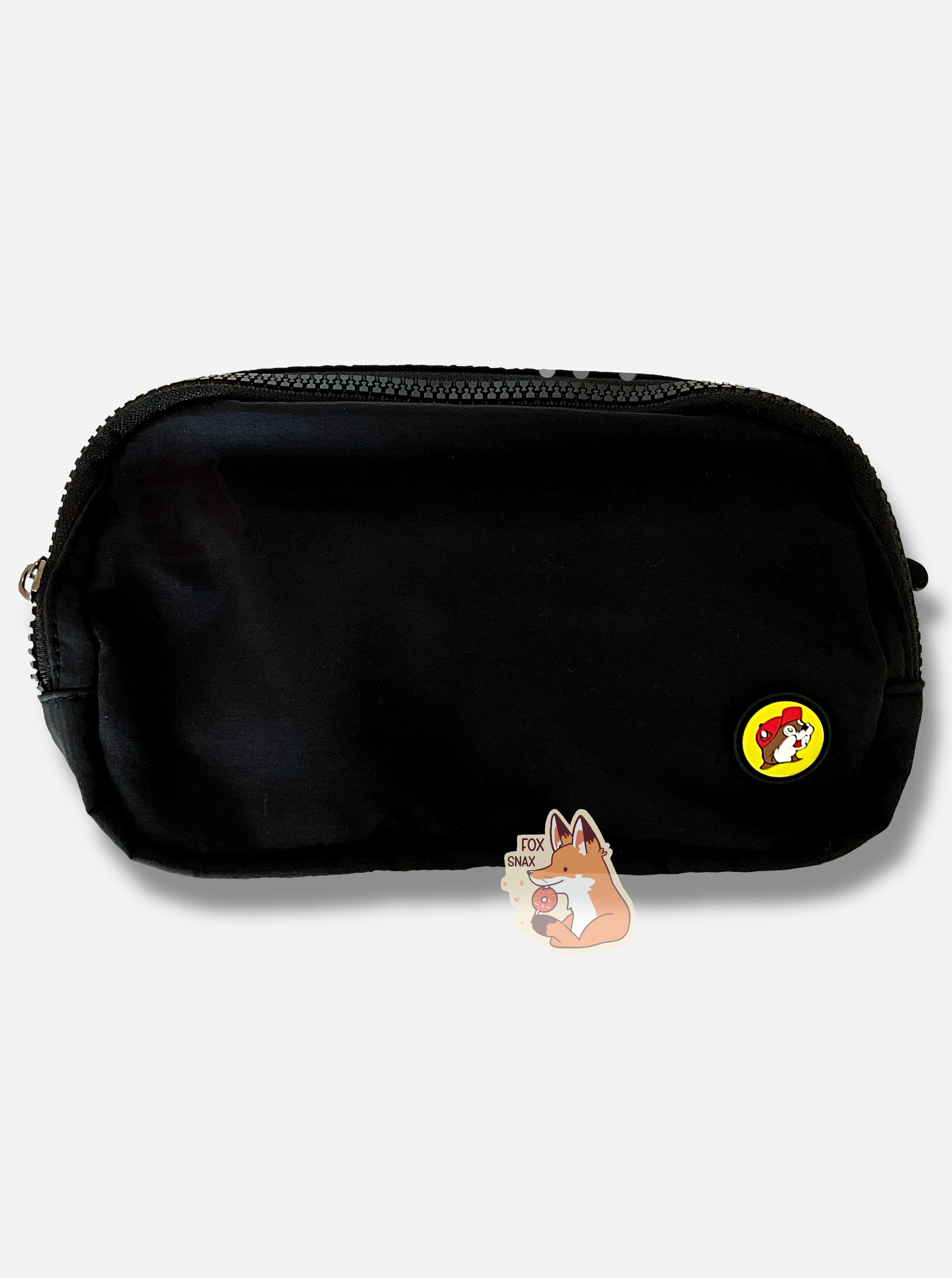 A picture of an oblong, black fanny pack, with a black zipper on top.  On the bottom right of the fanny pack is a small Buc-ee's logo, featuring Buc-ee the Beaver wearing a red ball cap.